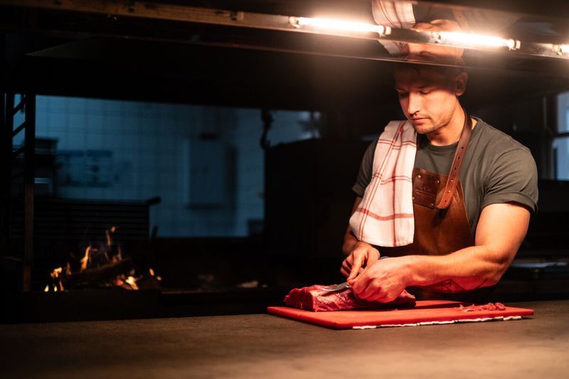 Chef cutting meat in the open kitchen