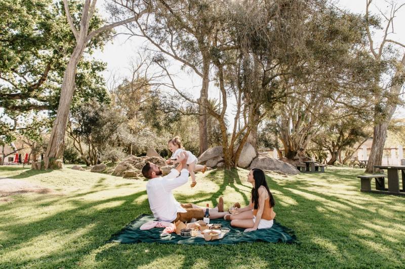 A young family enjoys a picnic under shady trees in wine country, showing how even vineyard escapes can double as relaxed best destinations for kids.