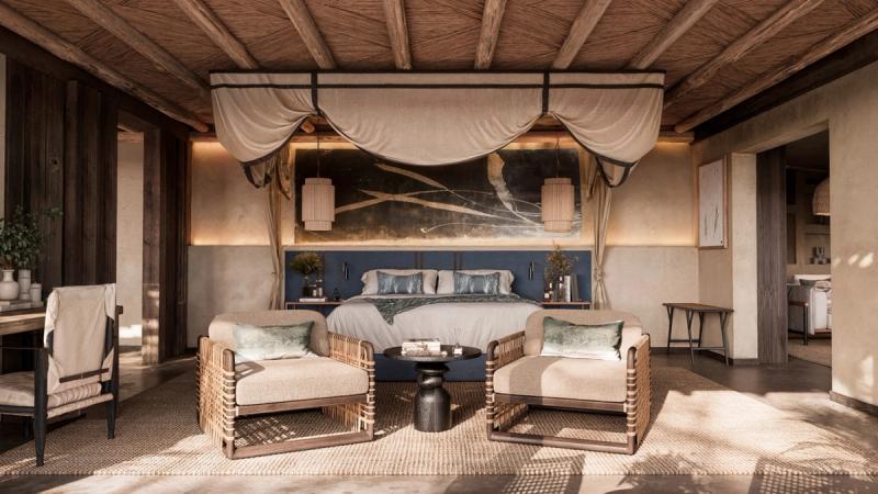 A spacious safari suite features natural textures, soft light, and a canopy-draped bed framed by earthy, contemporary décor.