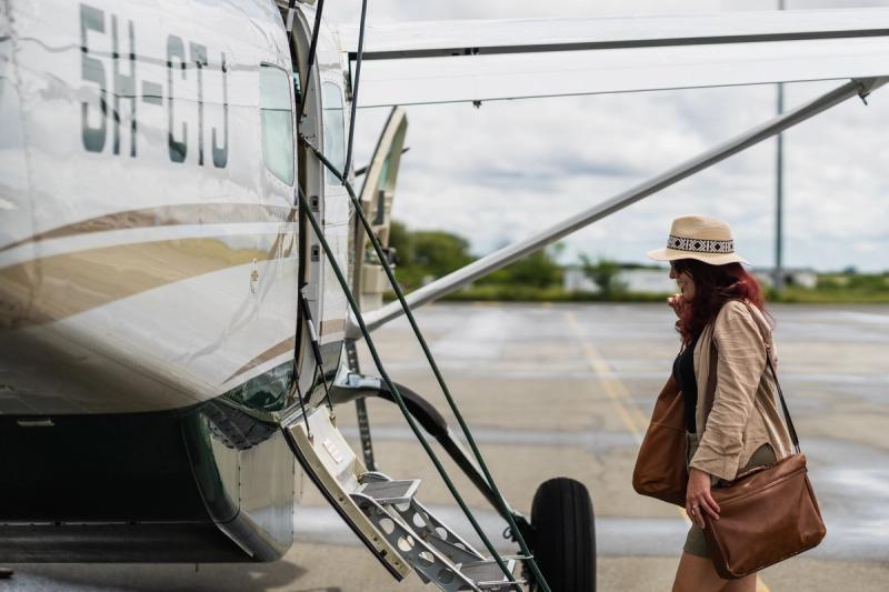 A woman steps confidently toward a bush plane, beginning her return trip to Africa.