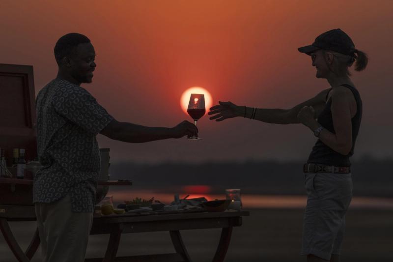 Sundowner drinks by the Zambezi River during a Lower Zambezi safari in Zambia
