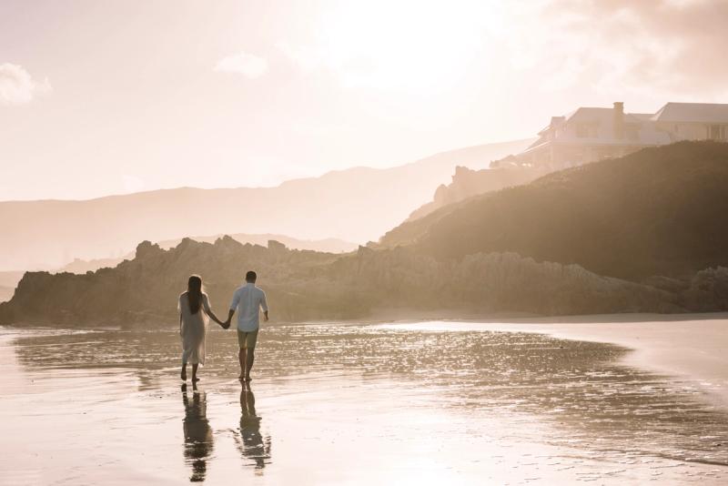 Couple strolling along the bach near Birkenhead House in Hermanus, South Africa