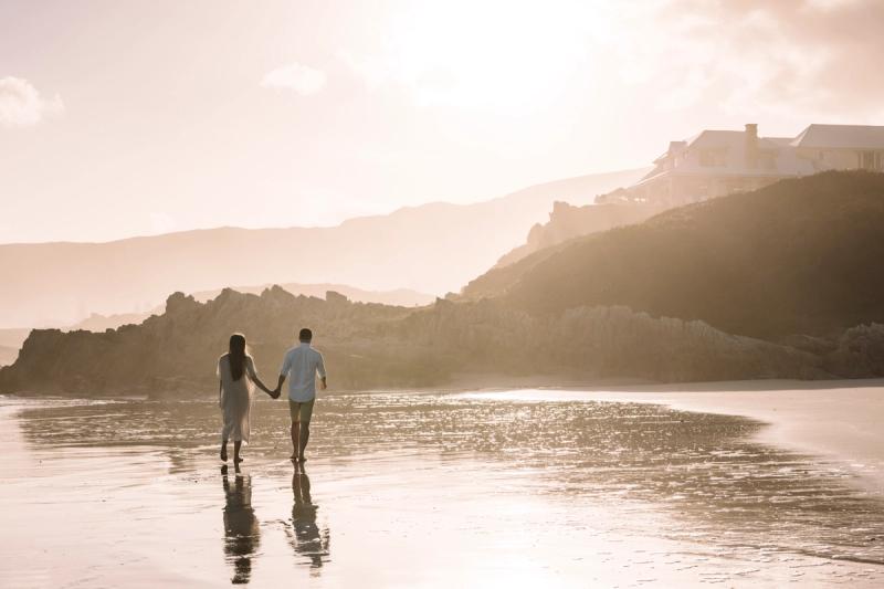 Couple strolling along the bach near Birkenhead House in Hermanus, South Africa