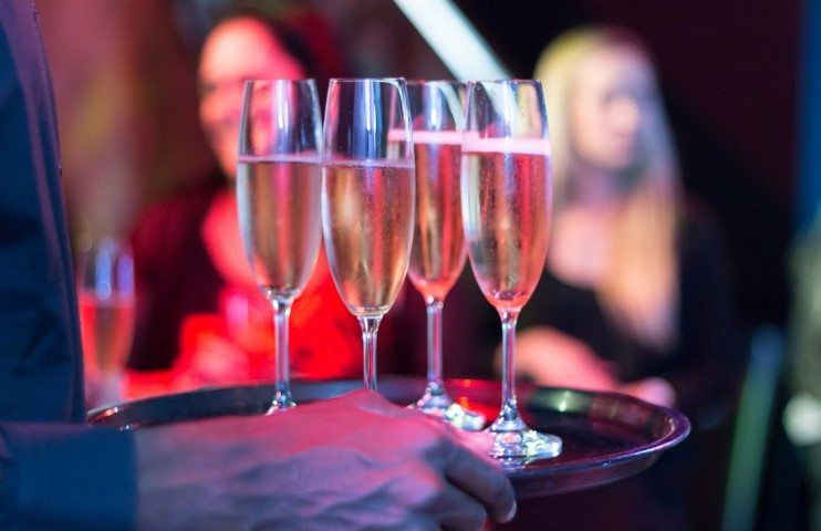 Gefüllte Sektgläser werden zum Anstoßen an Gäste verteilt