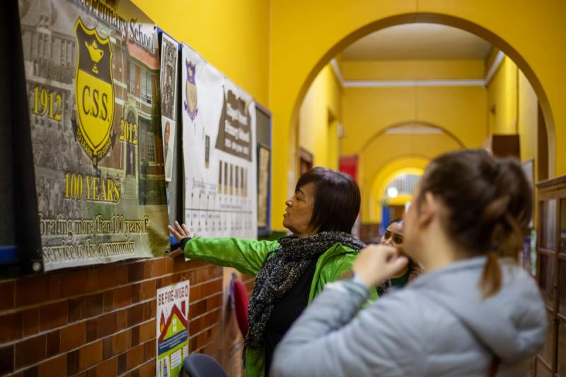 Rhino Africa volunteers review a historical school banner in a brightly colored hallway