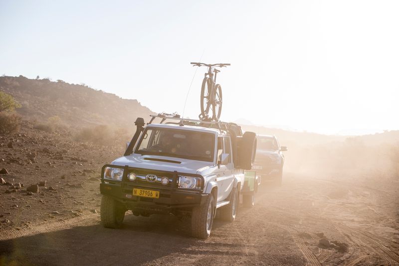 Transport vehicle with bike atop driving through the desert