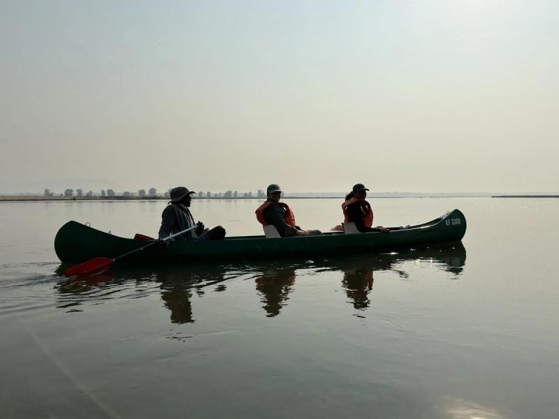Canoe safari on calm Zimbabwean waters, offering a low, close-to-nature wildlife perspective.