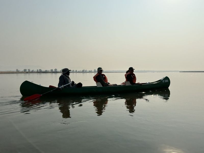 Canoe safari on calm Zimbabwean waters, offering a low, close-to-nature wildlife perspective.