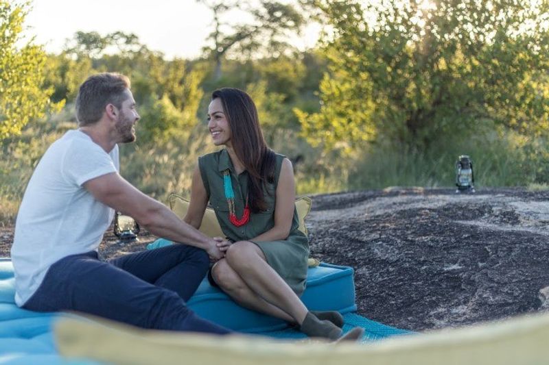 Flitterwochen im Sabi Sand Game Reserve: Ein Paar sitzt beim Sundowner im südafrikanischen Busch