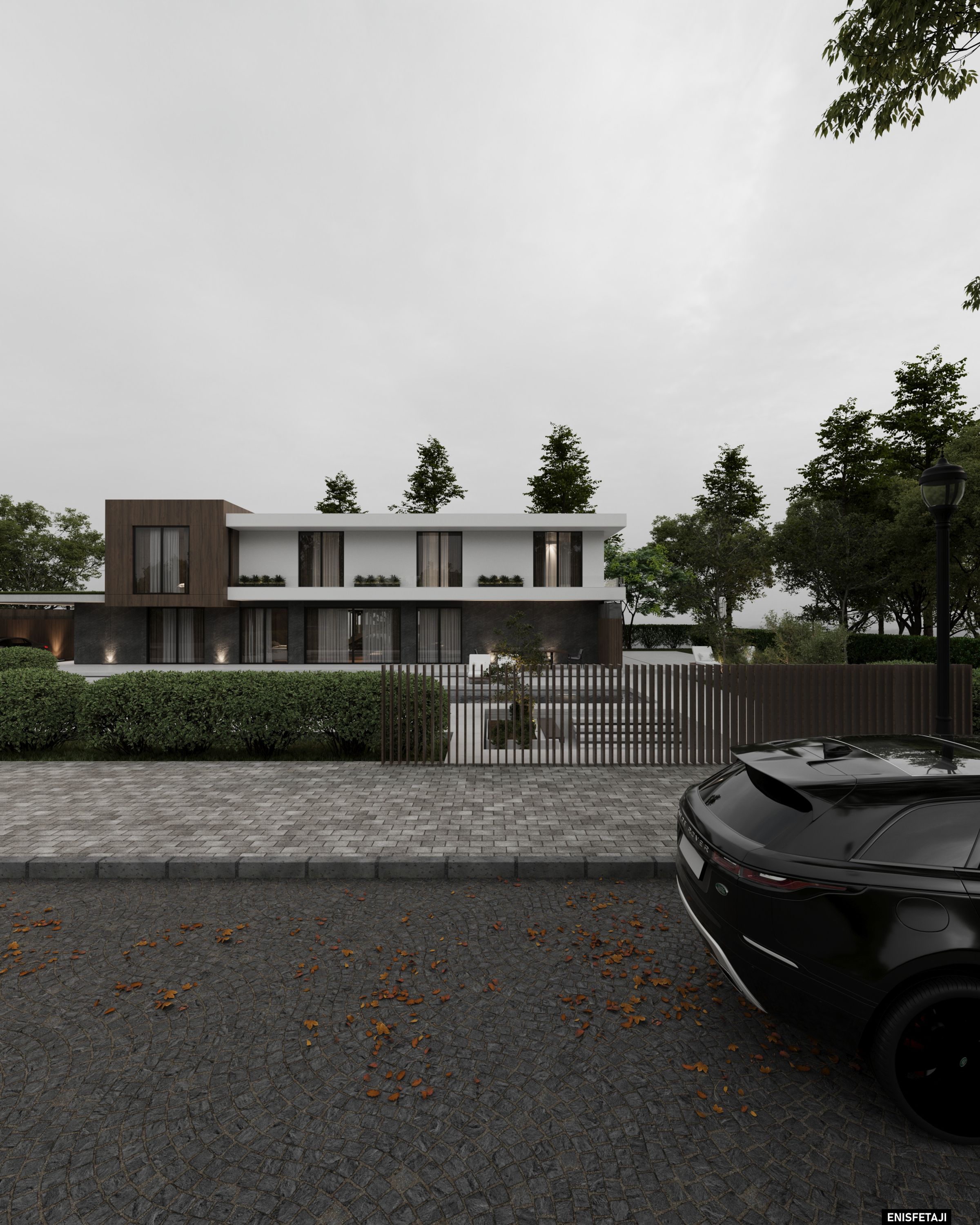 Modern villa seen from the street behind a hedge and gate
