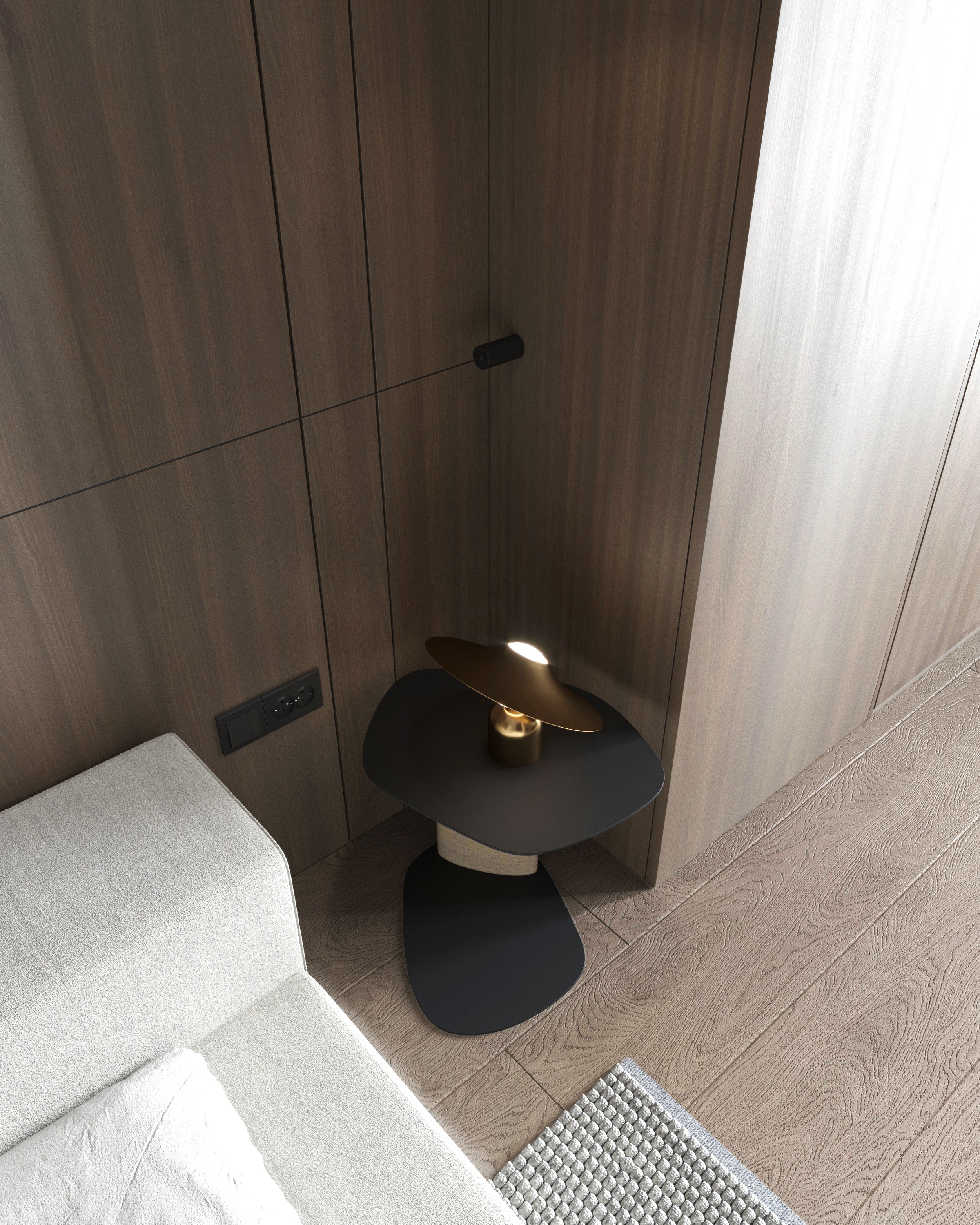 Side table with lamp next to a white sofa and wood wall, apartment in Skopje