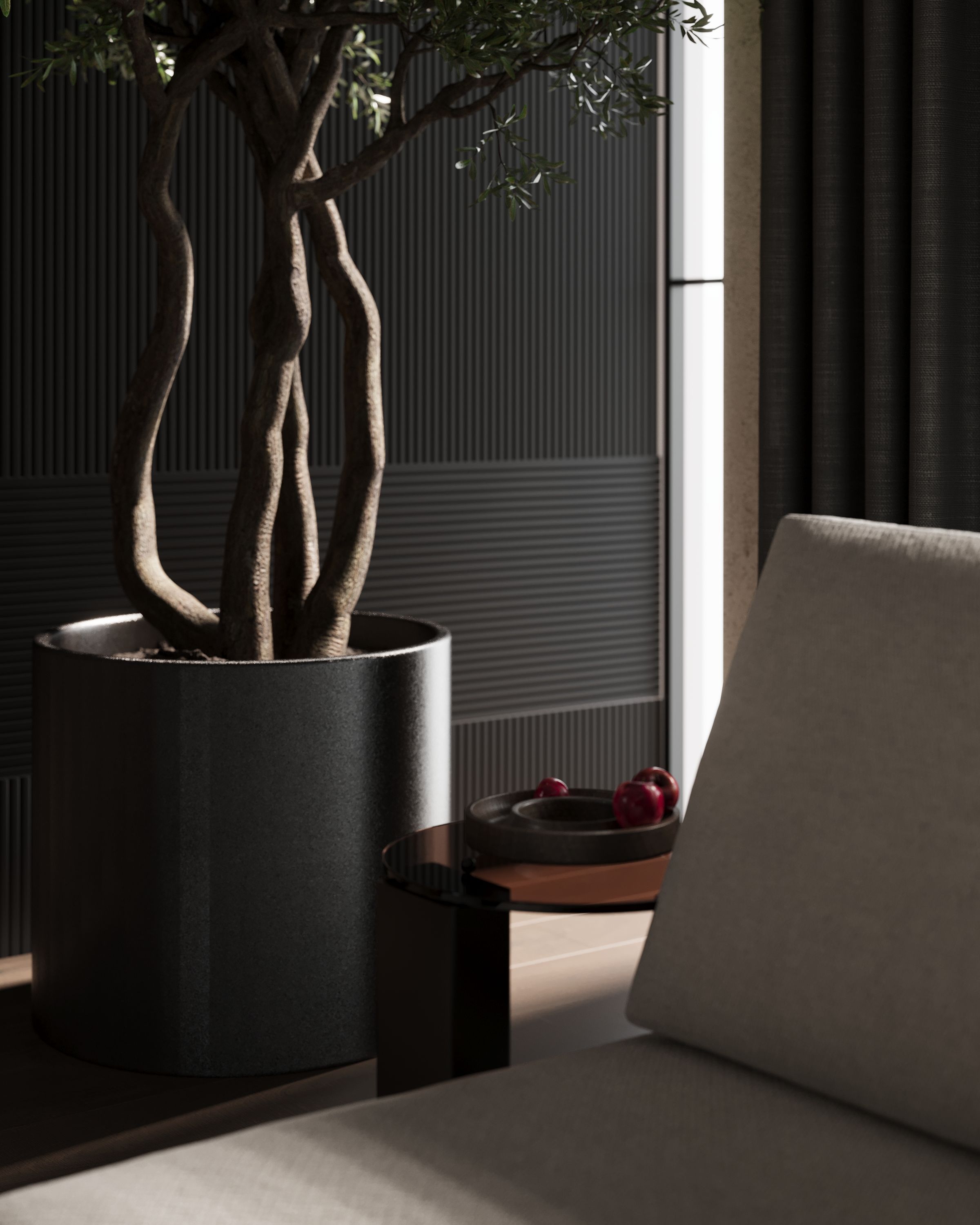 Olive tree in a black planter beside a beige sofa, Dark One apartment in Tetovo