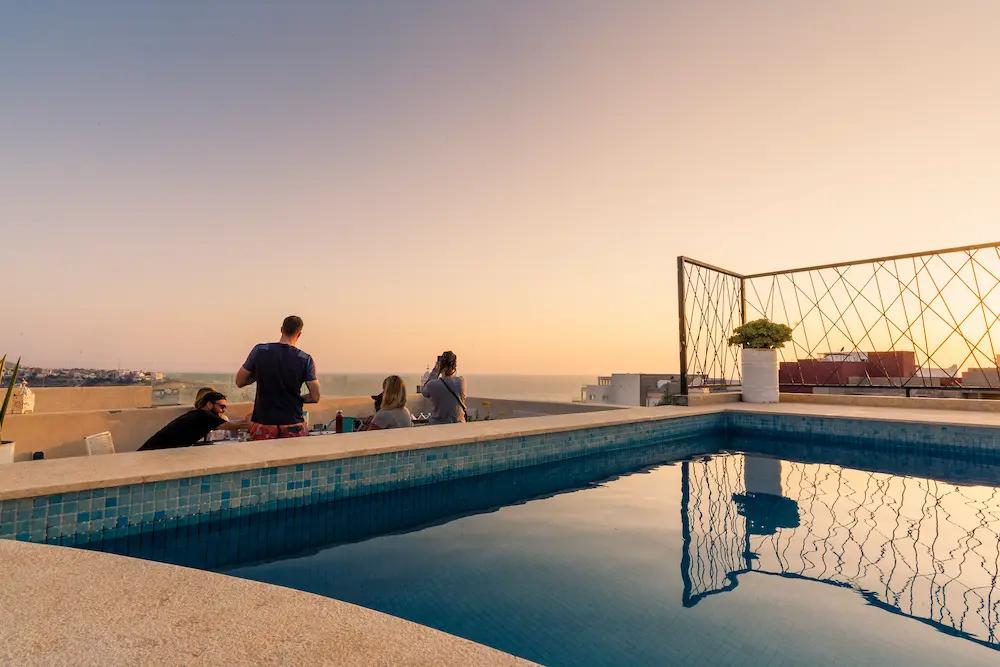 Sunset on the Rooftop with Surfers - Surf Camp Taghazout at The Yogi Surfer in Taghazout Bay, Morocco.