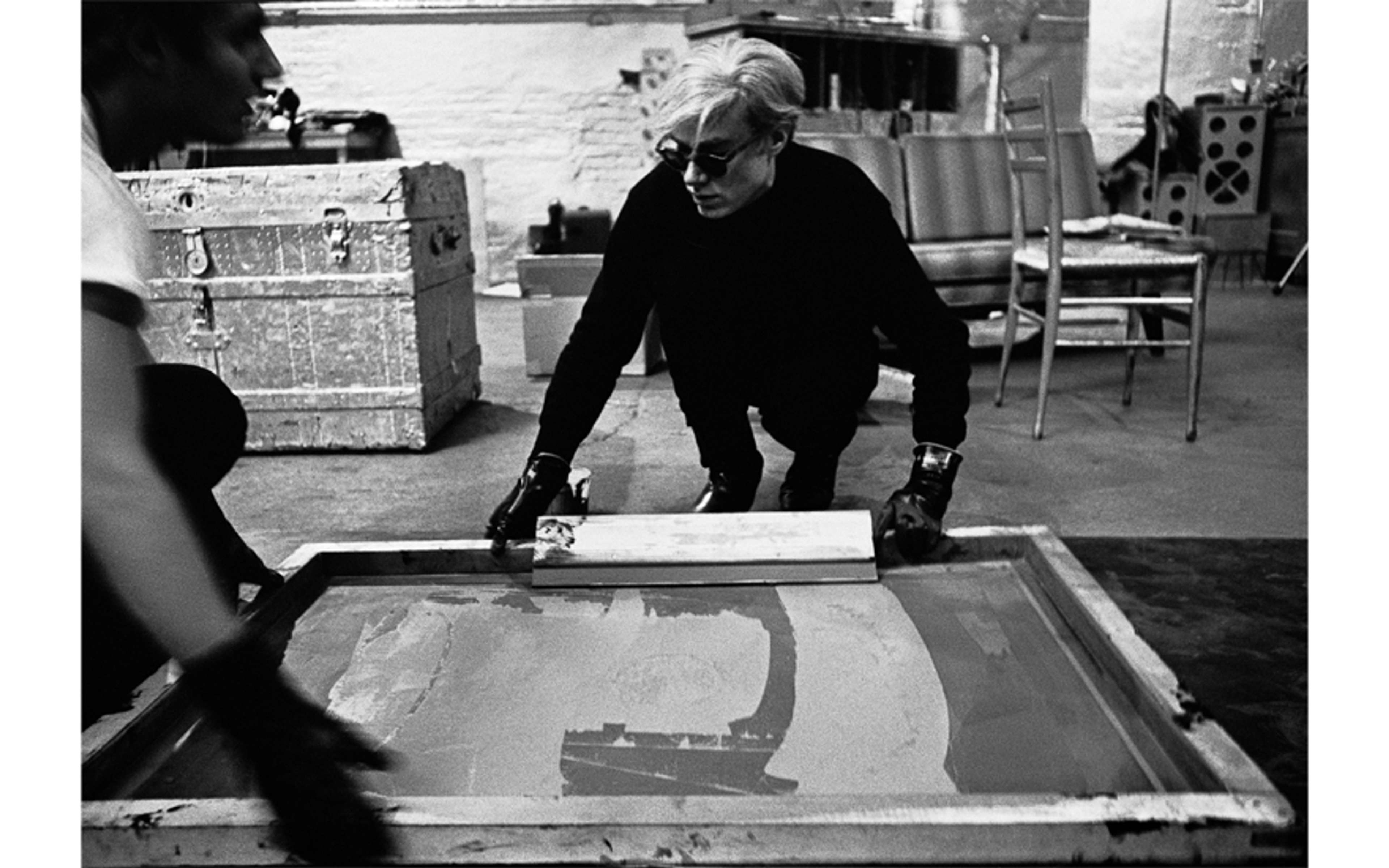 Andy Warhol helping Gerard Malanga to ink a silkscreen, 1964 - MyArtBroker