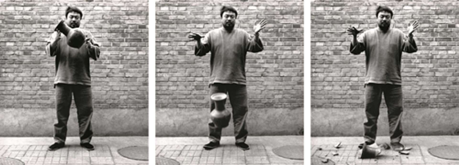 Three black and white photographs capturing artist Ai WeiWei standing against a brick wall. In each photo, he holds a Chinese urn, subsequently dropping it, resulting in the urn shattering on the ground.