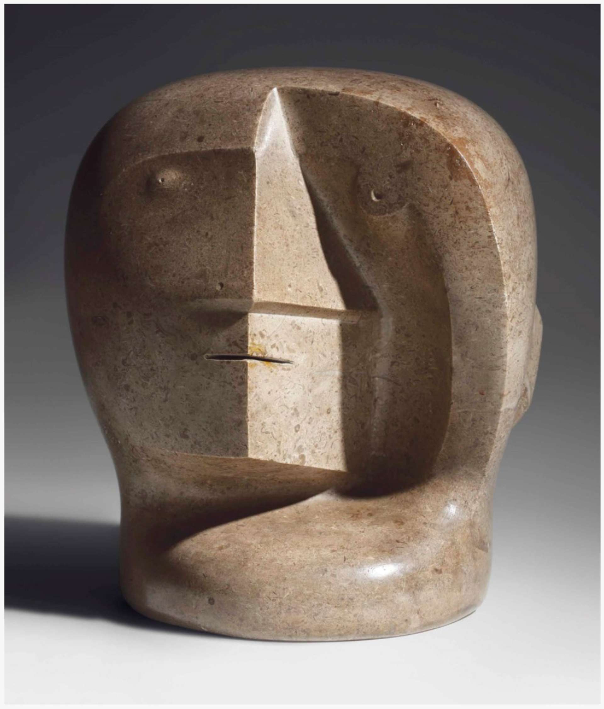 An early sculpture by Henry Moore featuring a jagged and unsymmetrical head with distinct Aztec chacmool features. The sculpture rests on a round base.