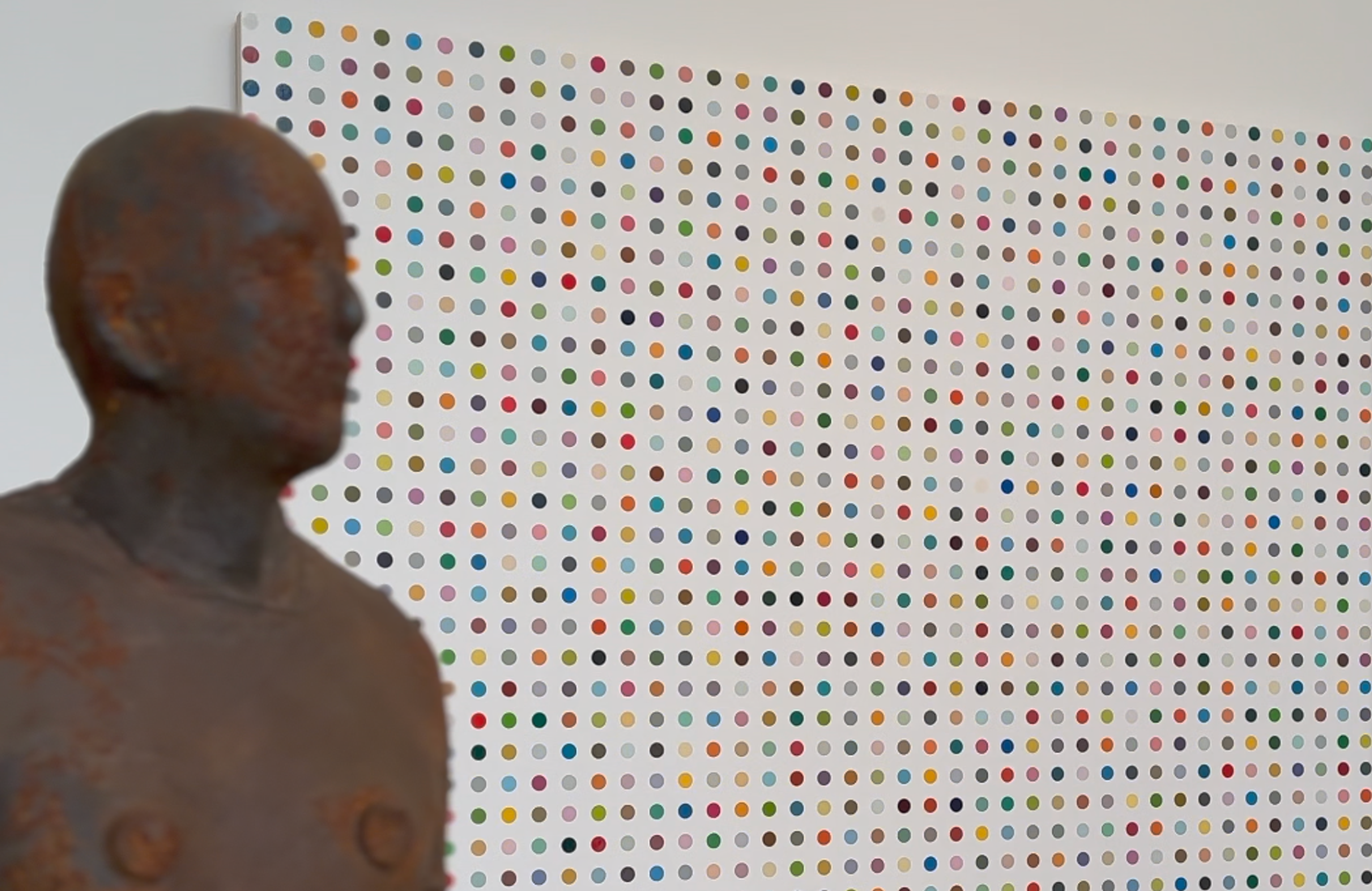 Damien Hirst painting behind Anthony Gormley statue