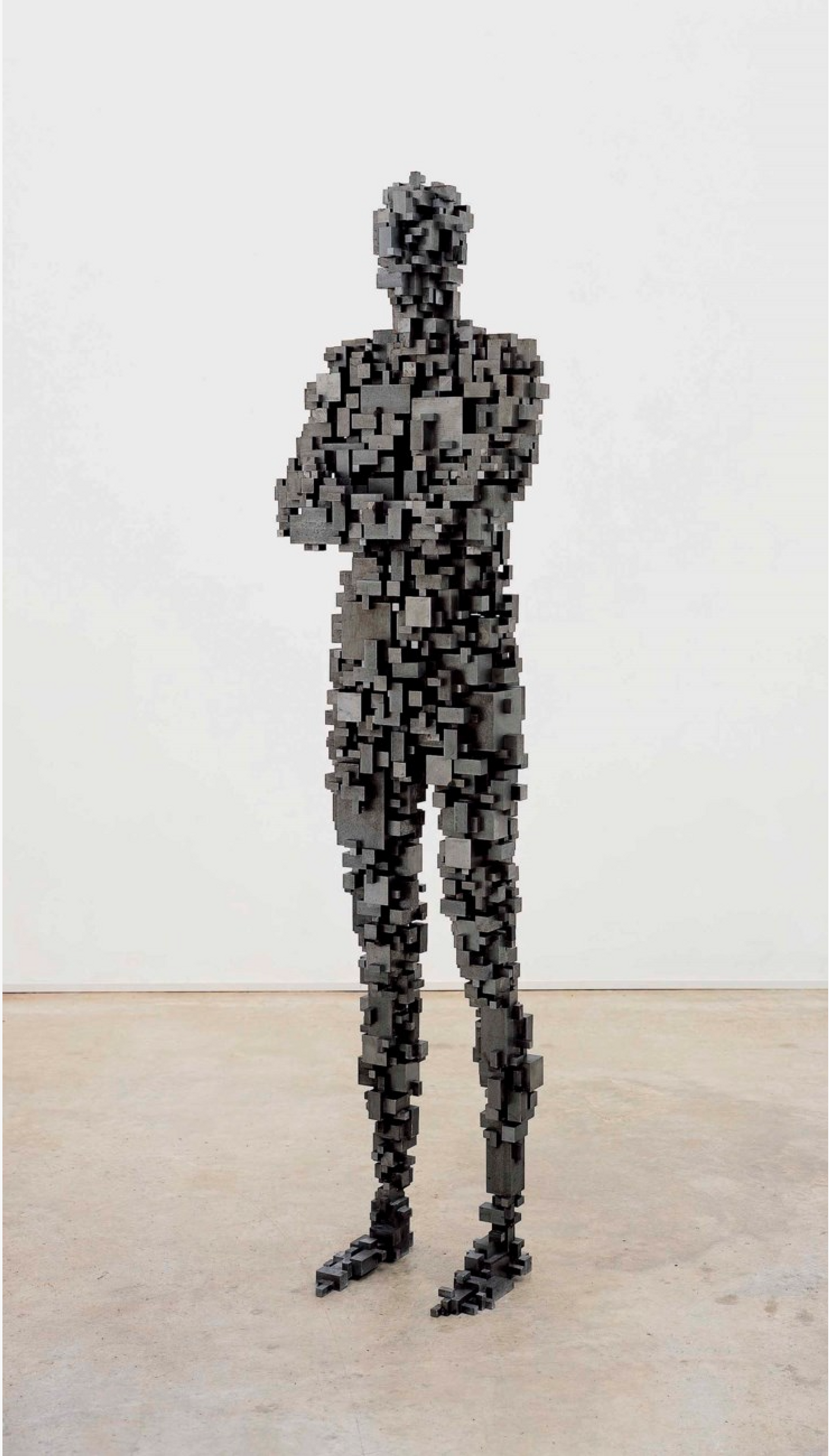A life-sized human sculpture created using interlocking steel blocks, depicting a figure with feet positioned apart and arms crossed in front of the chest. The sculpture embodies the essence of the human form, devoid of distinctive features. The use of tessellating steel blocks adds an intriguing texture and structure to the sculpture's composition.