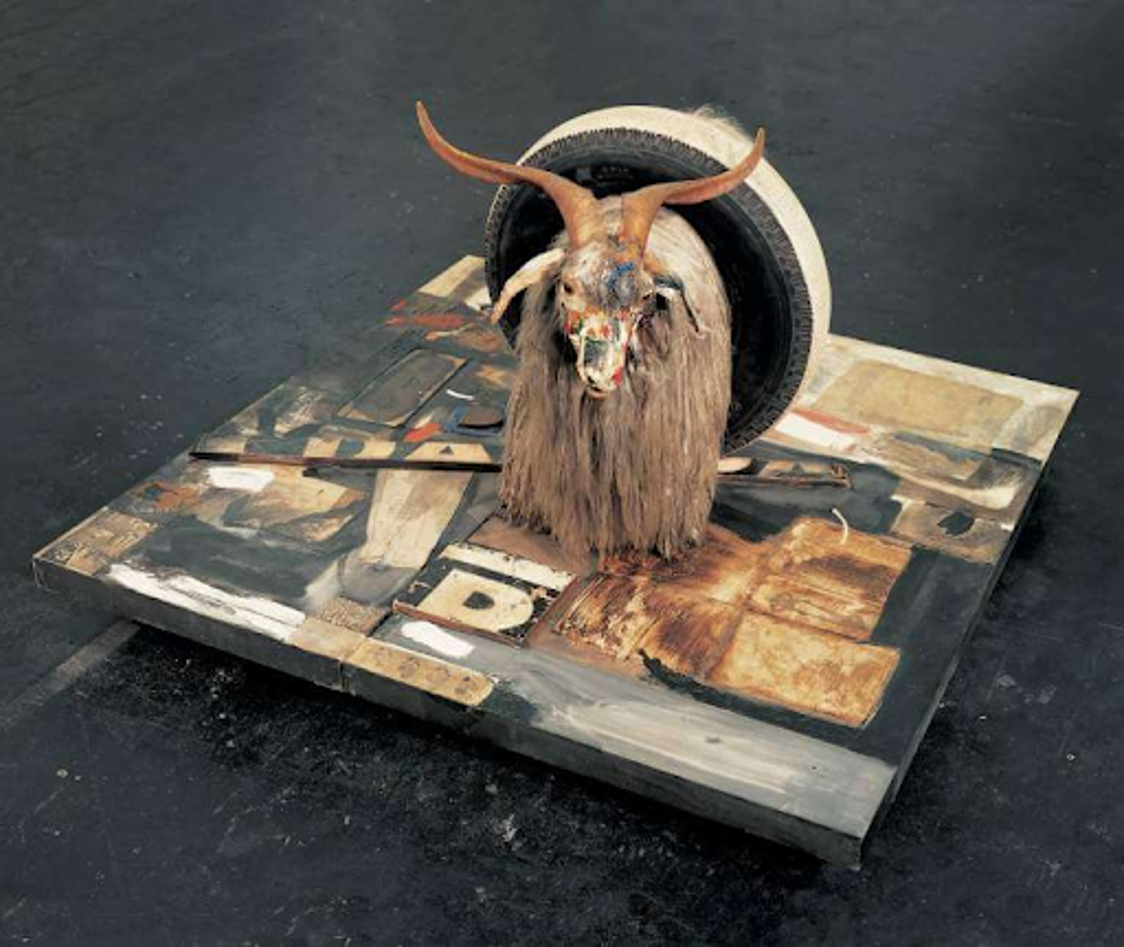 Robert Rauschnberg’s Monogram. An assemblage of a painted canvas layered with metal and wood. On top of it is a goat that is painted on with a tire around its body.