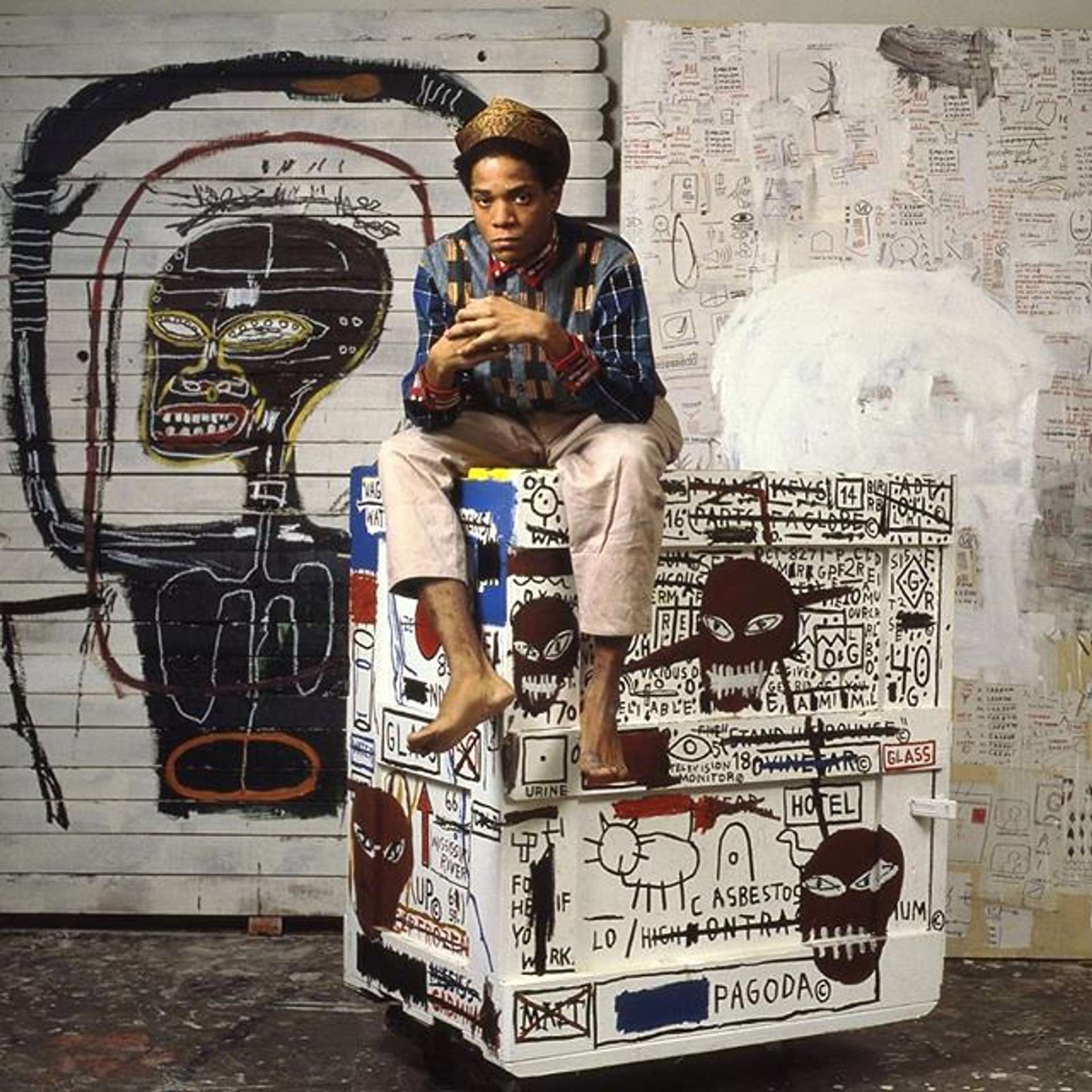 Jean-Michel Basquiat sat on top of a case covered in his distinctive symbols 