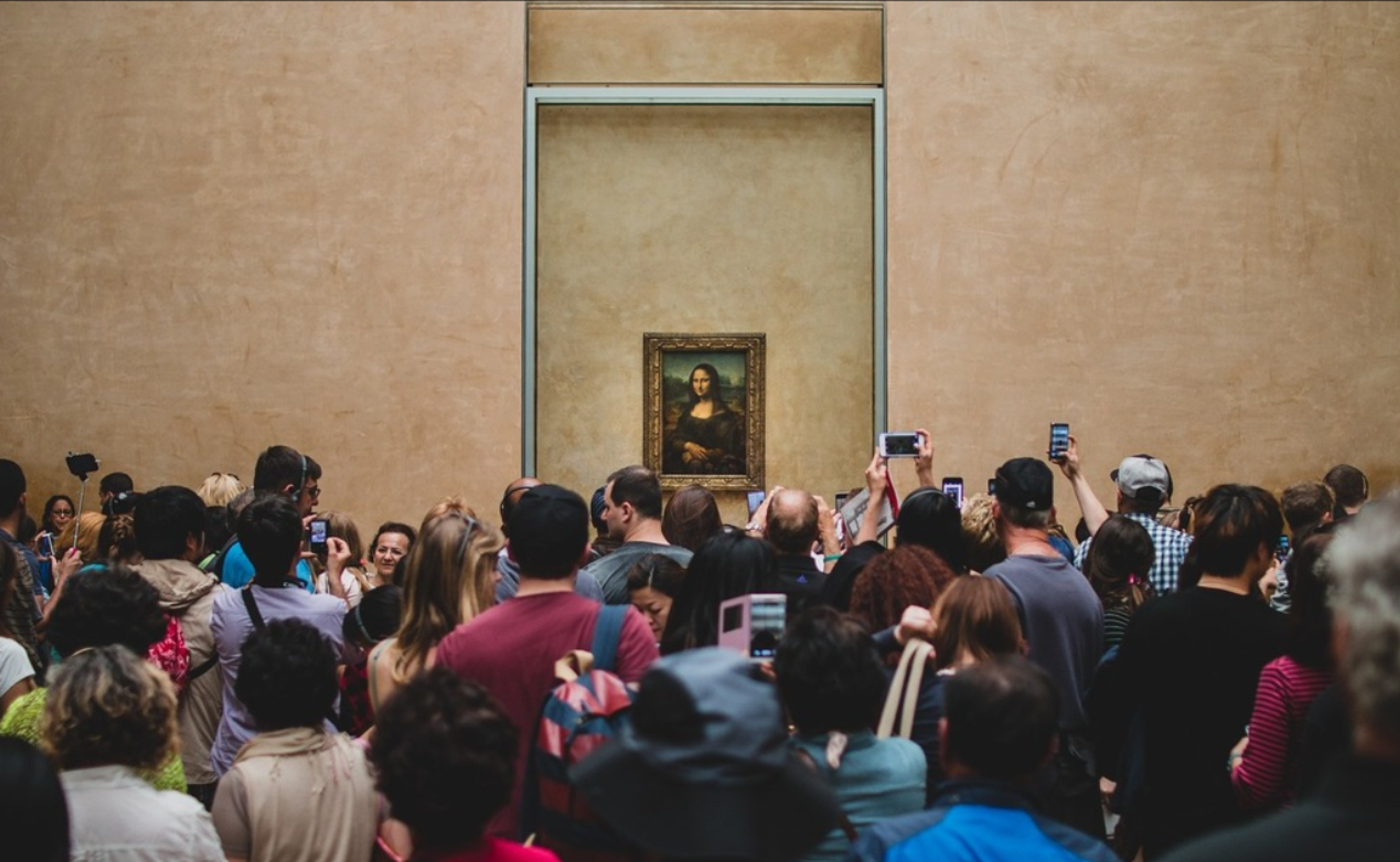 A crowd of people taking pictures of a small artwork