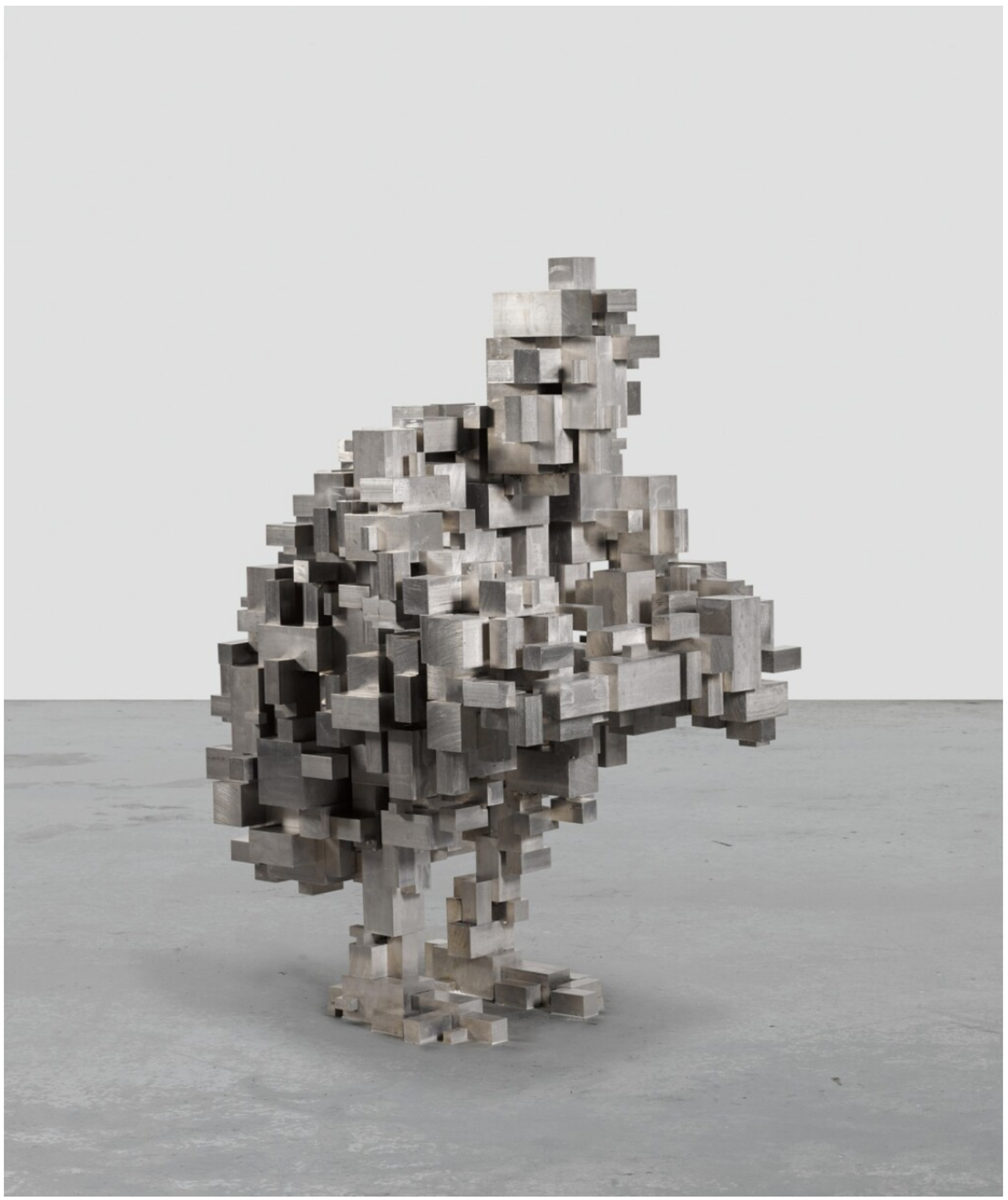 A sculpture of a human figure, crouched and hugging its knees, constructed using small stainless steel blocks. 