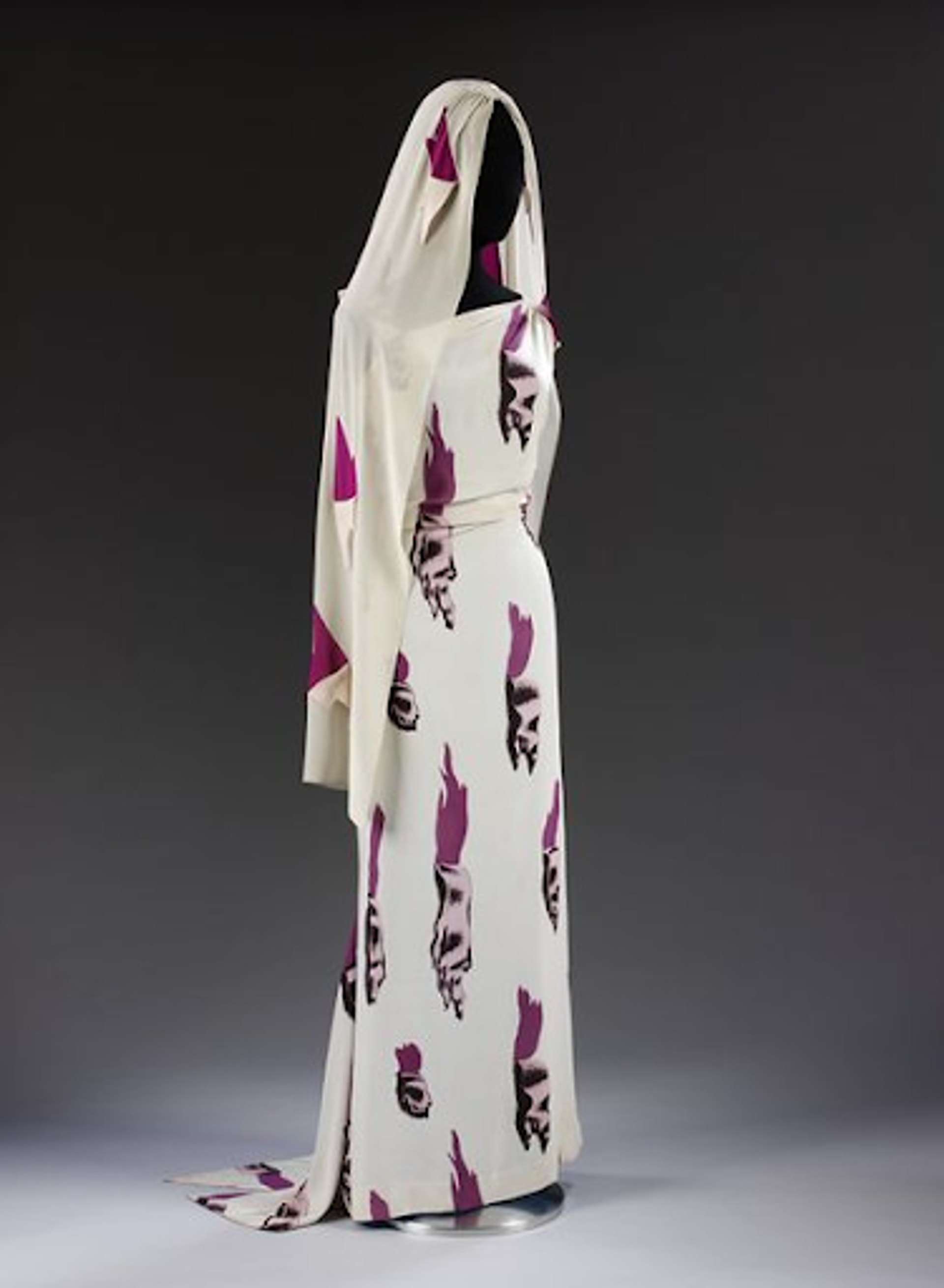 Photograph of long white gown and matching veil with purple prints.