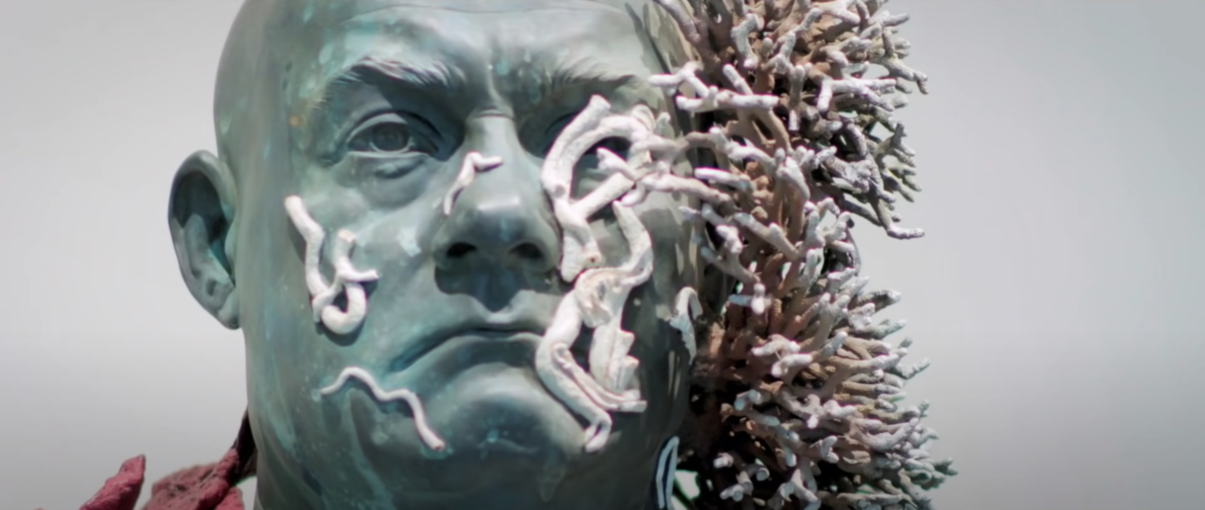 A sculpture of the artist Damein Hirst's face, covered in mock coral.