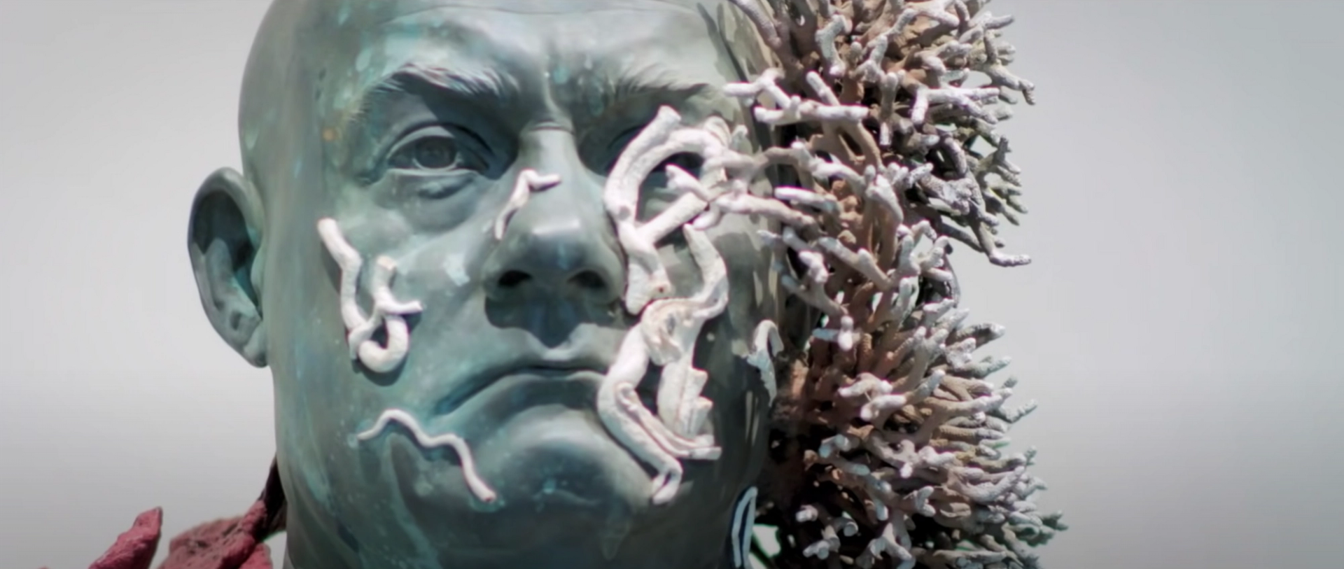 A sculpture of the artist Damein Hirst's face, covered in mock coral.