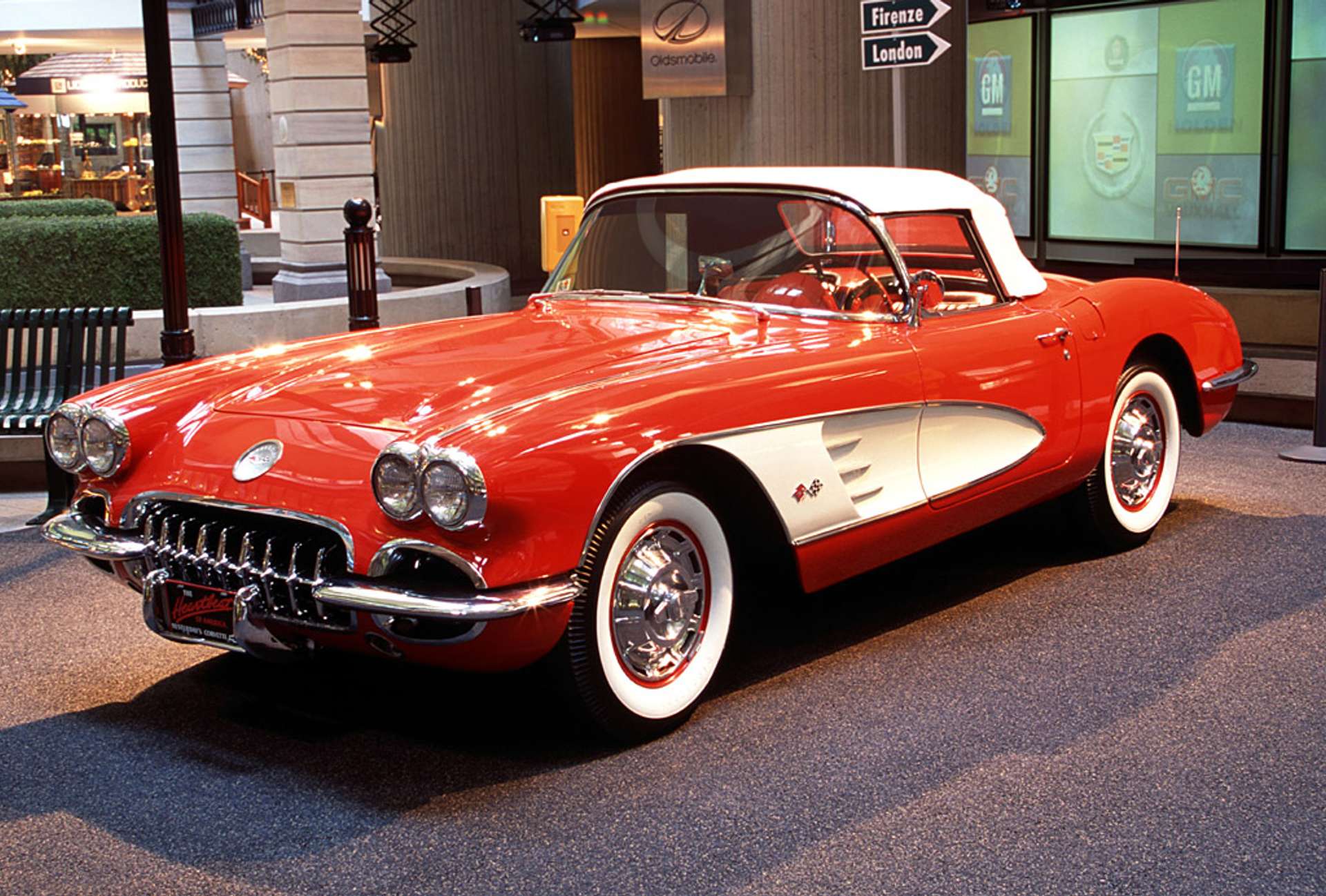 A vintage tomato red Chevrolet Corvette in a shopping mall.