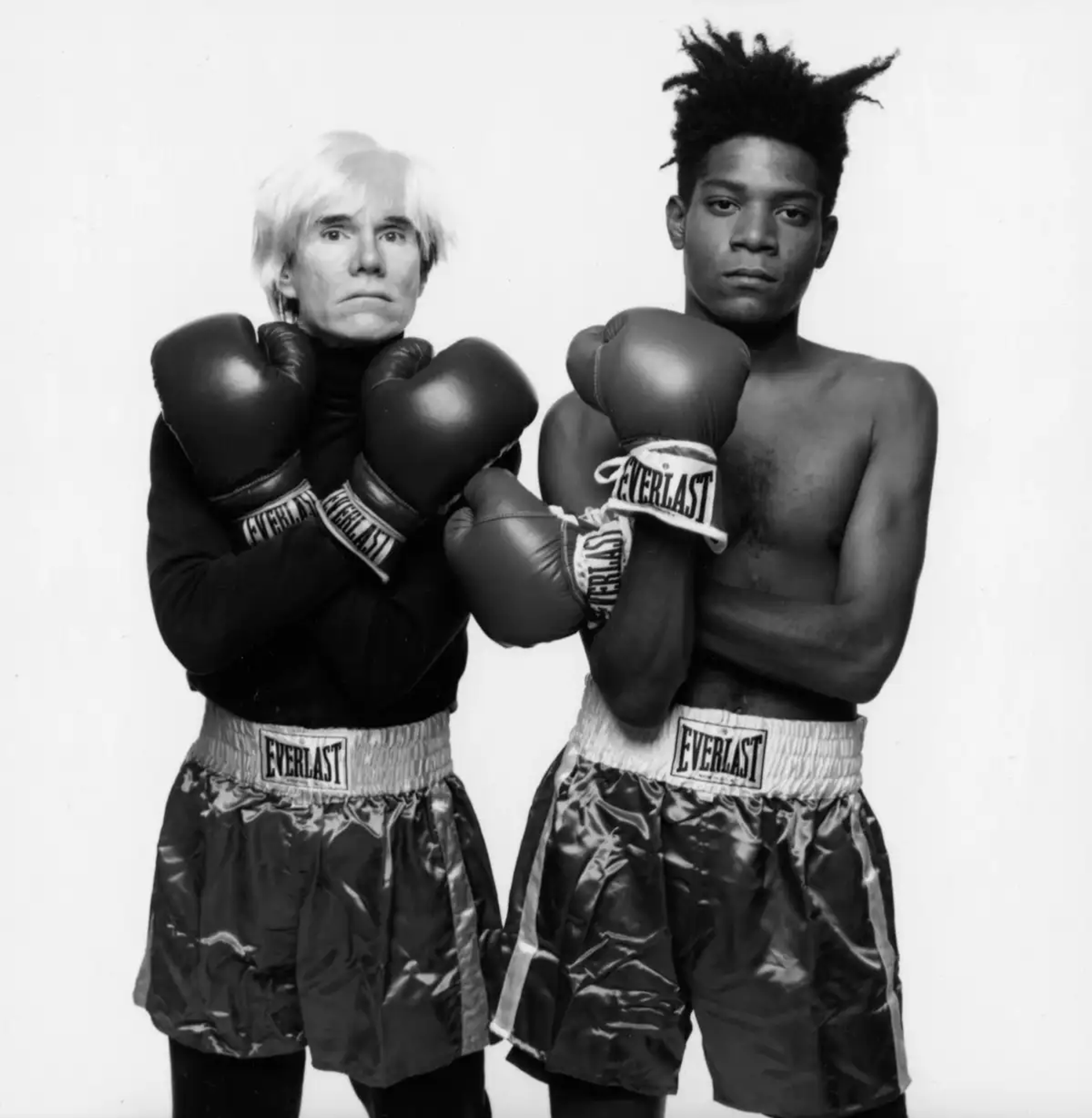 Black and white photograph of Andy Warhol, Jean-Michel Basquiat, Bruno Bischofberger and Fransesco Clemente, New York, 1984.