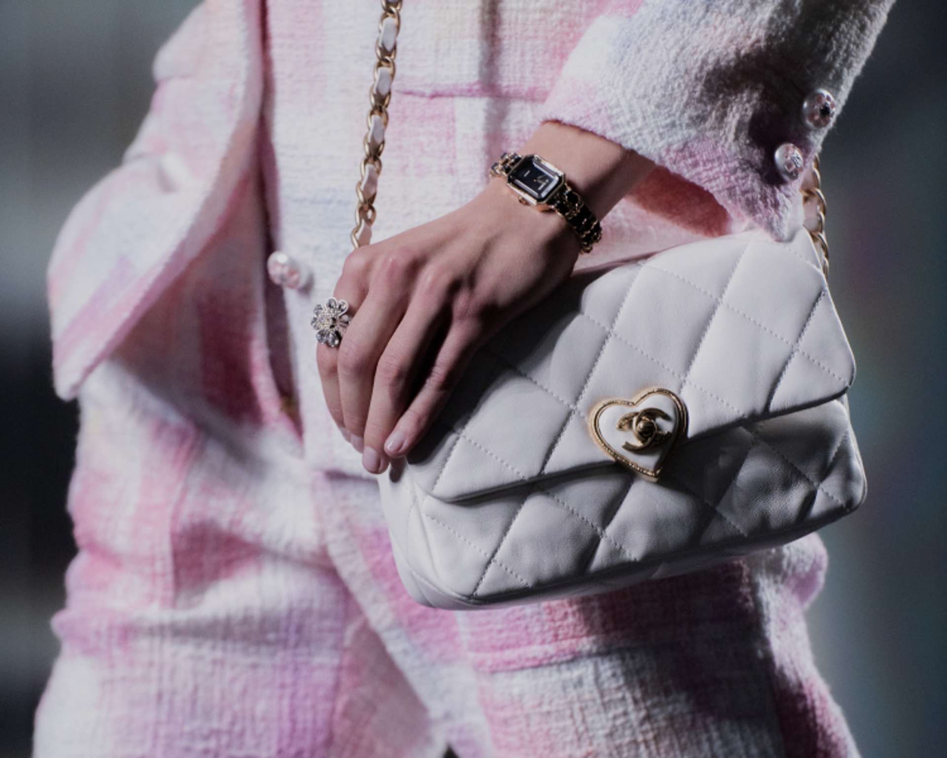 Close-up of a Chanel bag on the runway with gold heart-shaped hardware around the double C clasp