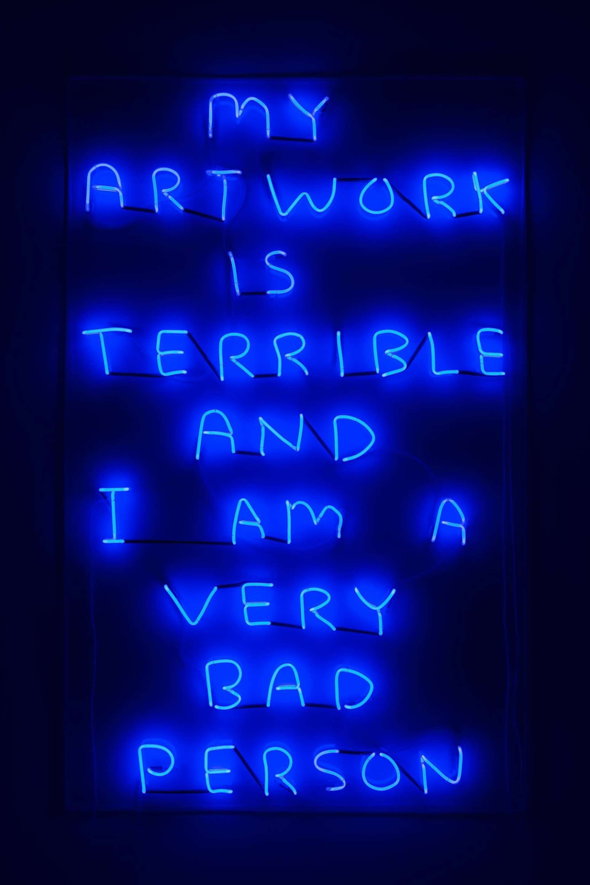 An image of the neon sign My Artwork by artist David Shrigley, a blue neon which reads “My artwork is terrible and I am a very bad person.”