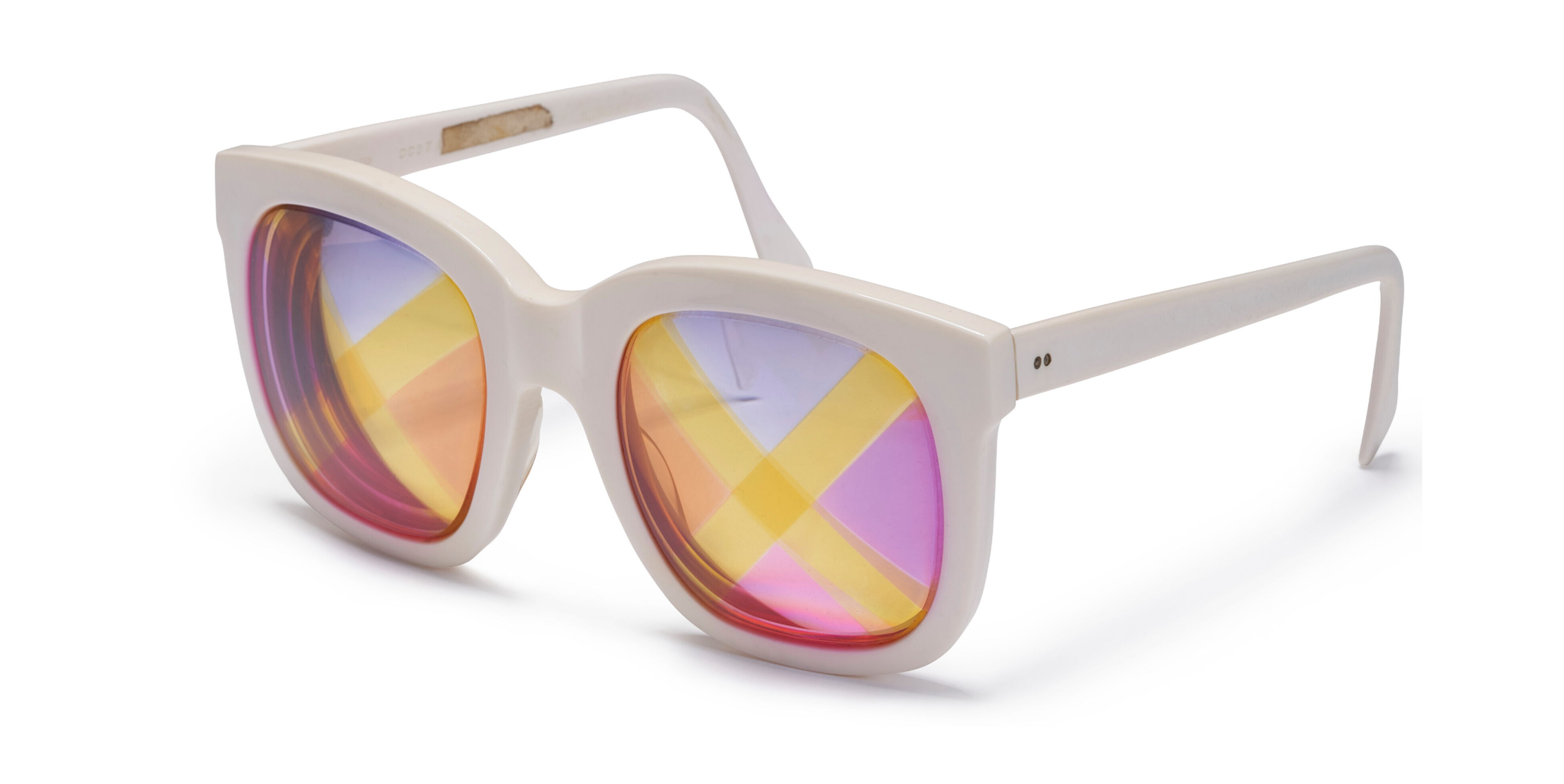 An image of a pair of sunglasses with white plastic frames, the lenses with yellow X's against purple, pink, and orange background