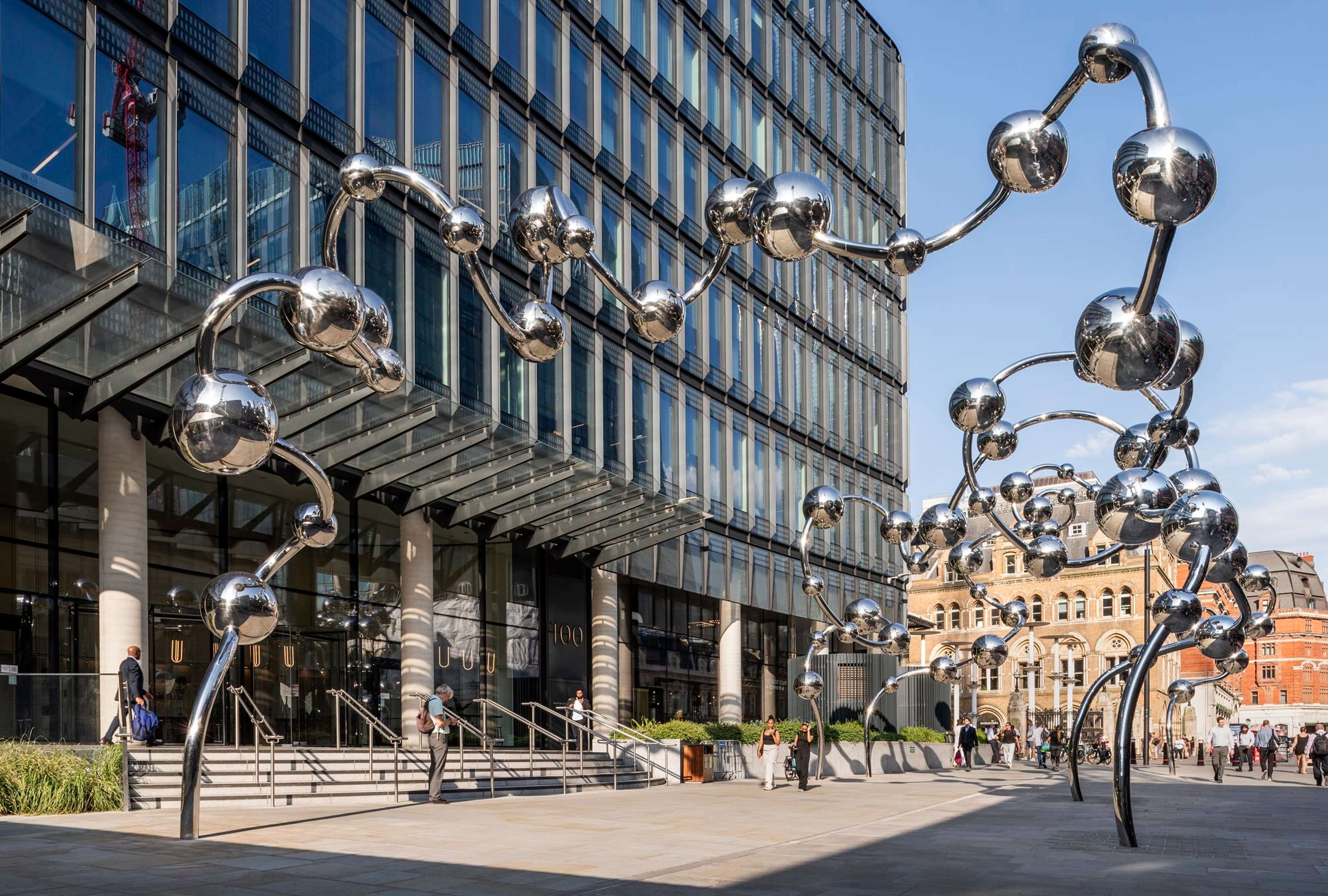 Image of large, silver installation-sculpture, featuring large spheres connected by wire 