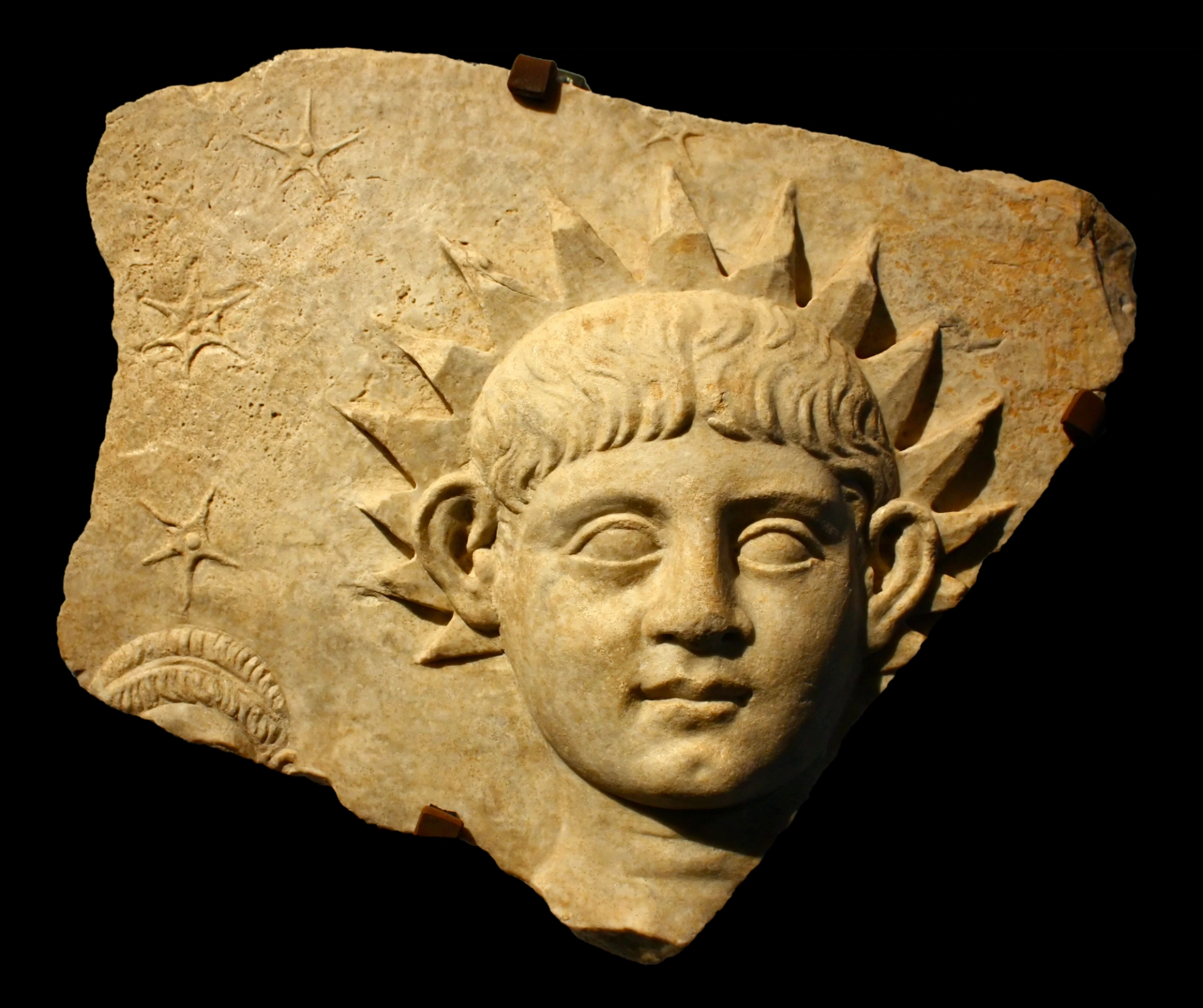 Ancient Roman sculpture of a young boy with radiating sunlight from his hair.