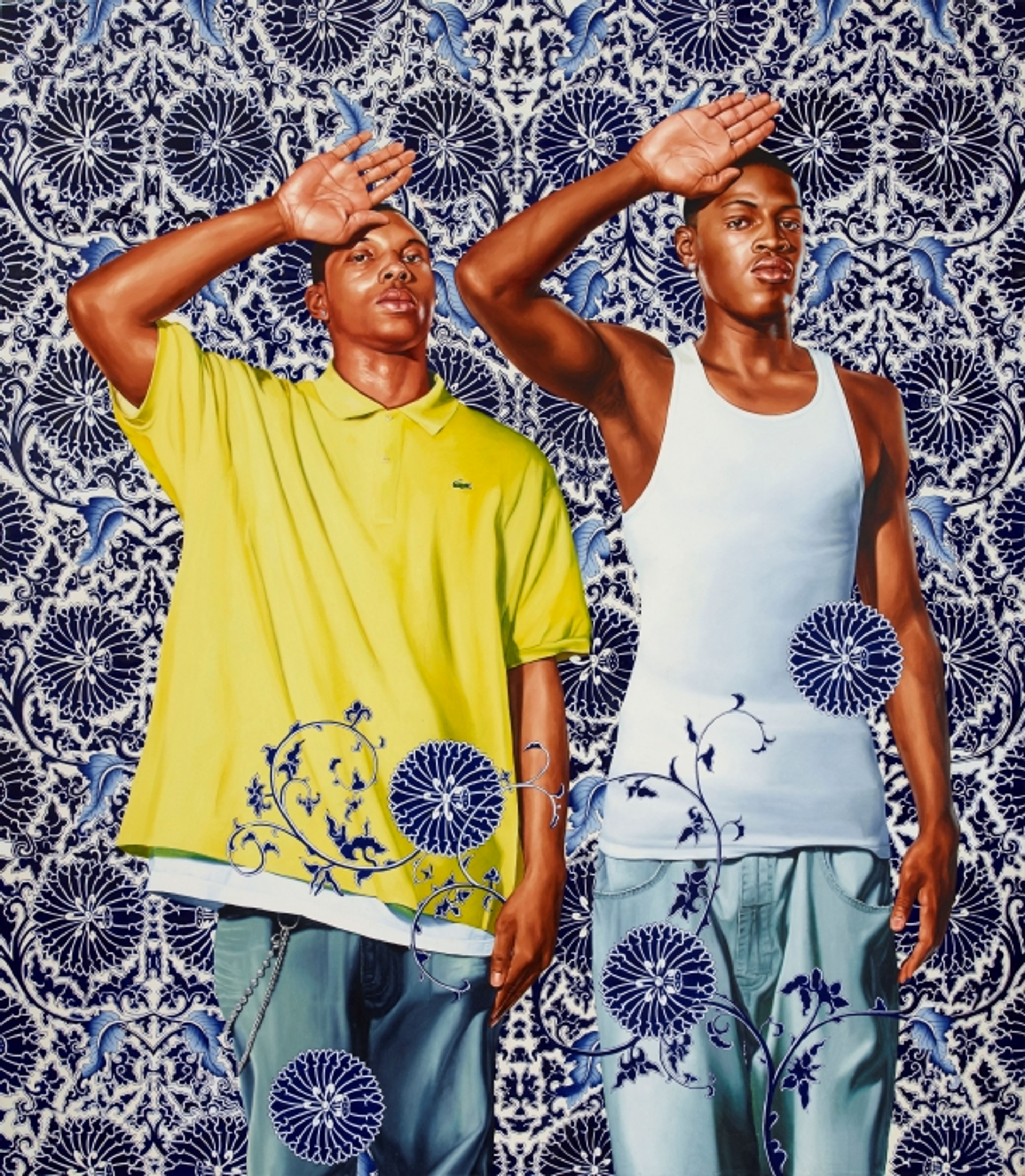 Kehinde Wiley’s Two Heroic Sisters of the Grassland. Two black men standing beside one another with one hand raised open on their forehead, and the other hand on the side of their bodies. One wears a yellow shirt, the other  white tank top in front of an ornate blue patterned background.