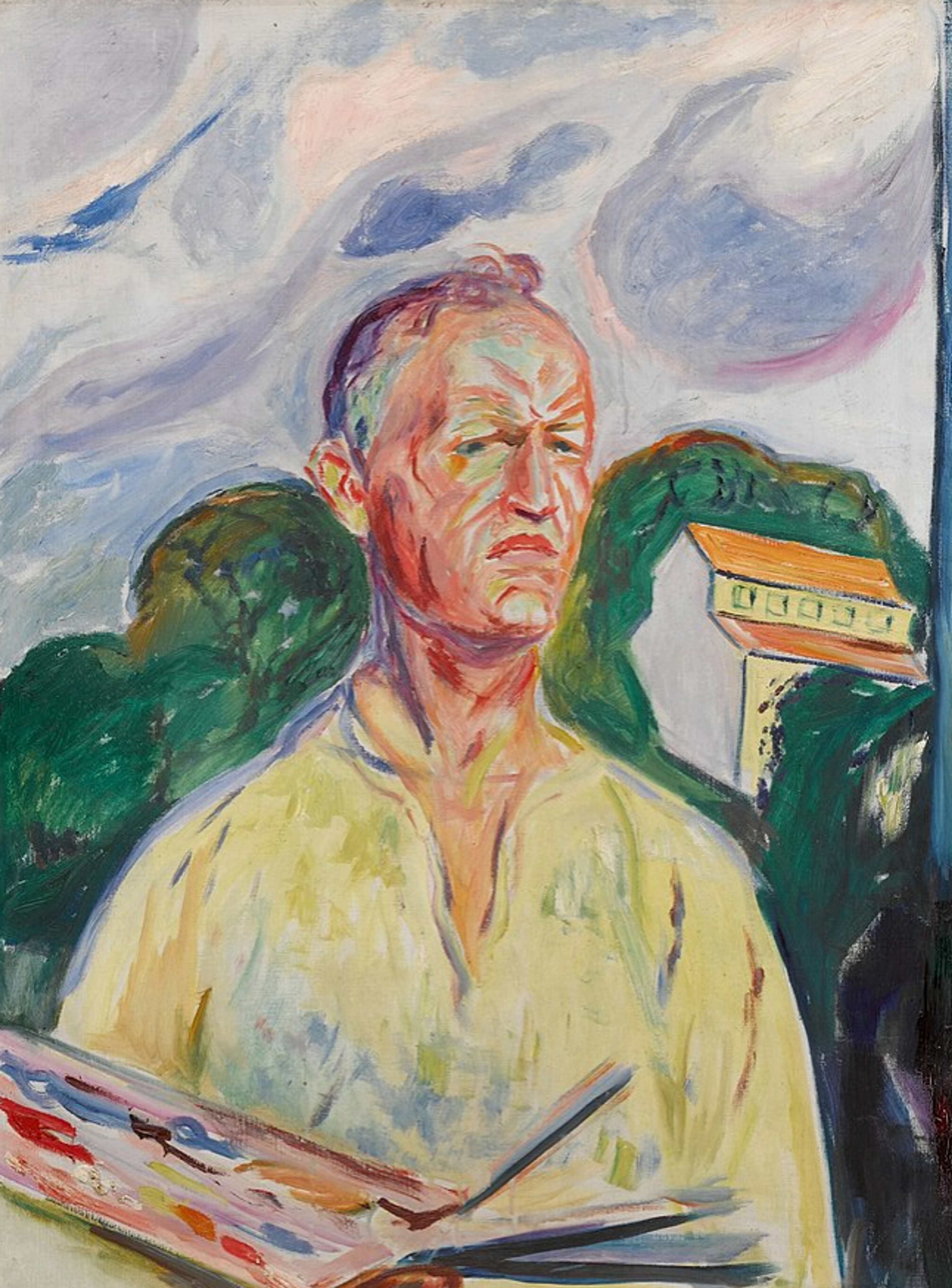 A colourful self-portrait of Edvard Munch showing the artist standing outdoors, holding a palette and brushes. He wears a light yellow shirt, with a stern, introspective expression. Behind him, his studio at Ekely is visible. The style is Impressionistic, with short brushstrokes. The sky above is painted in swirling, soft hues of blue, grey, and pink.