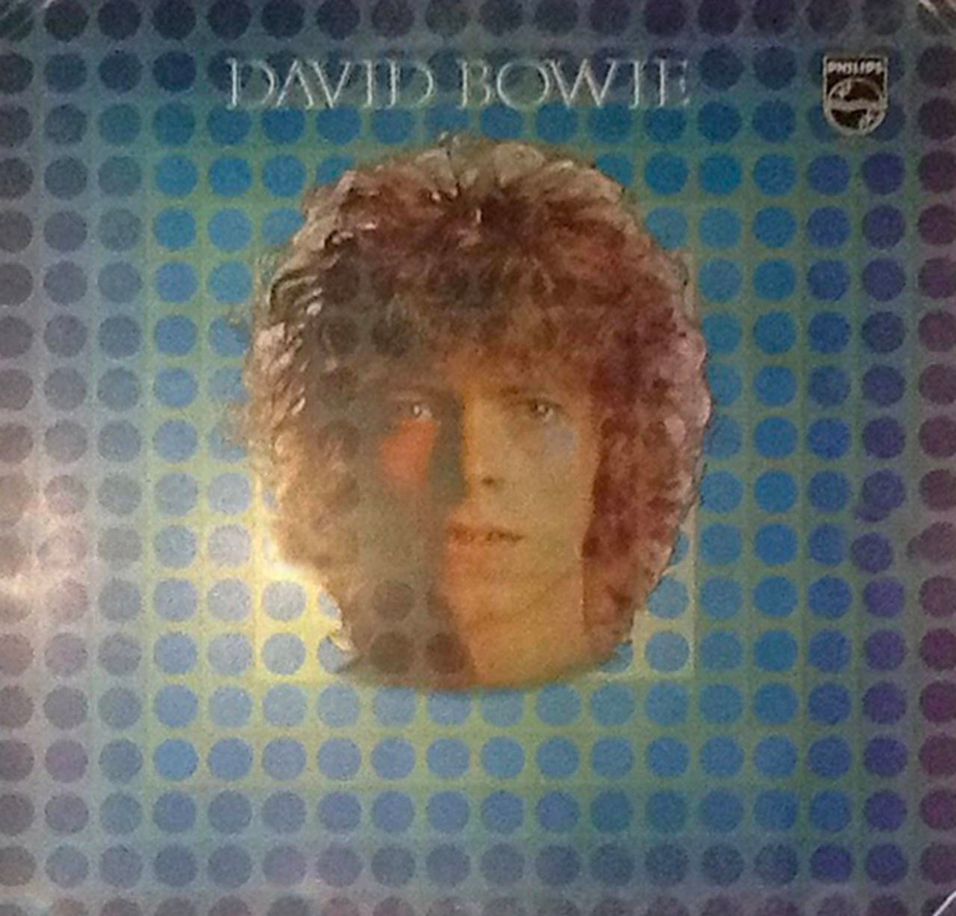 David Bowie's head floating against a blue and purple op art background of repeating circles.