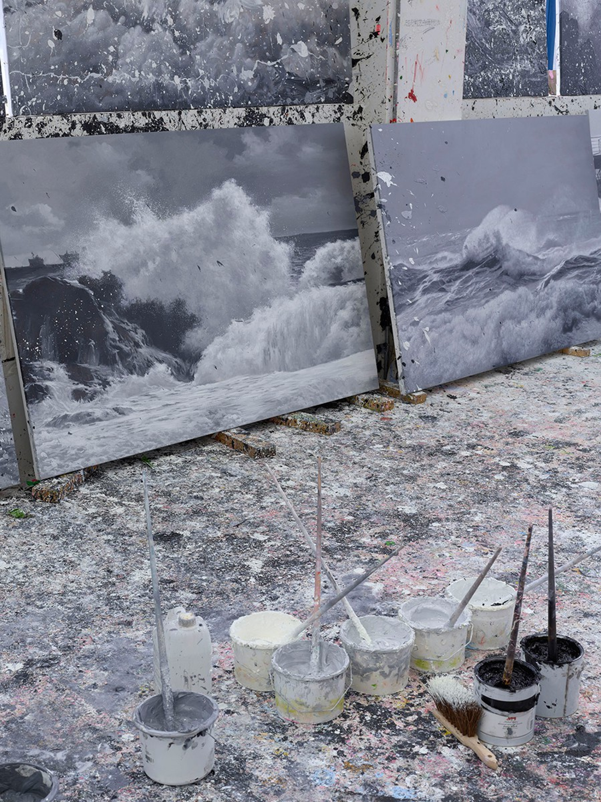 An image of some of Damien Hirst's seascapes on the floor of the artist's studio.