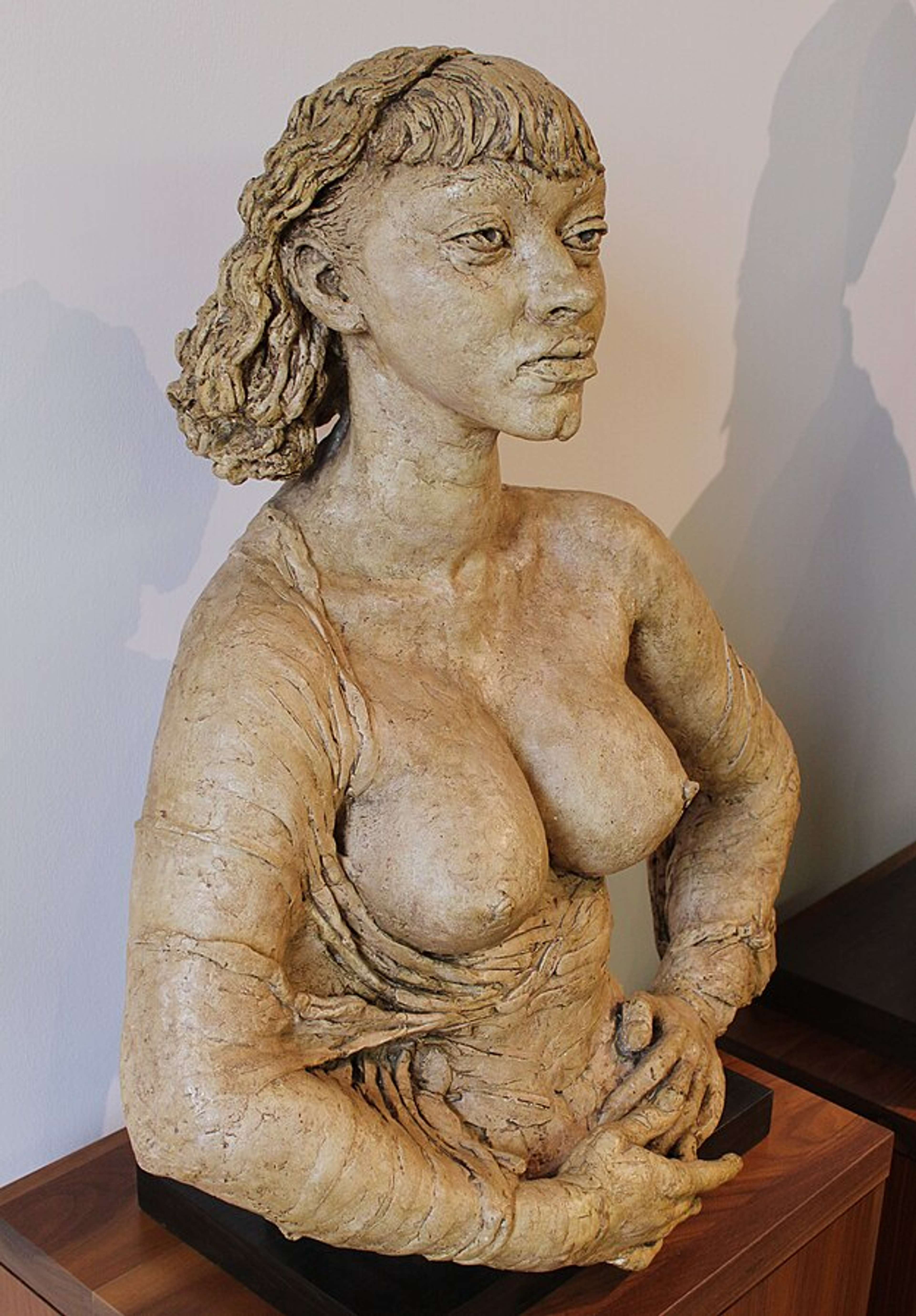 Bust of a woman with short hair and her breasts bare 