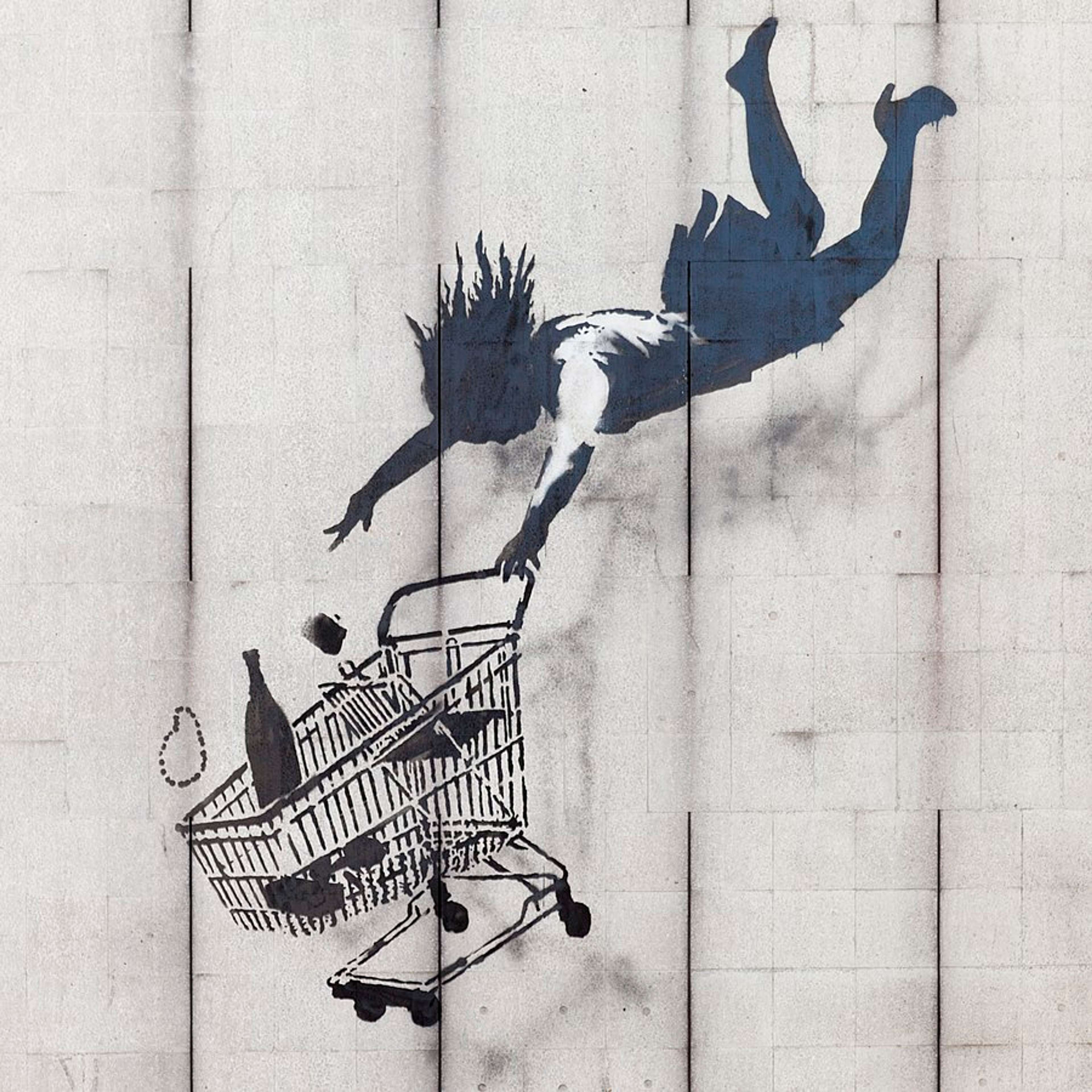 Graffiti stencil of falling woman and a shopping cart