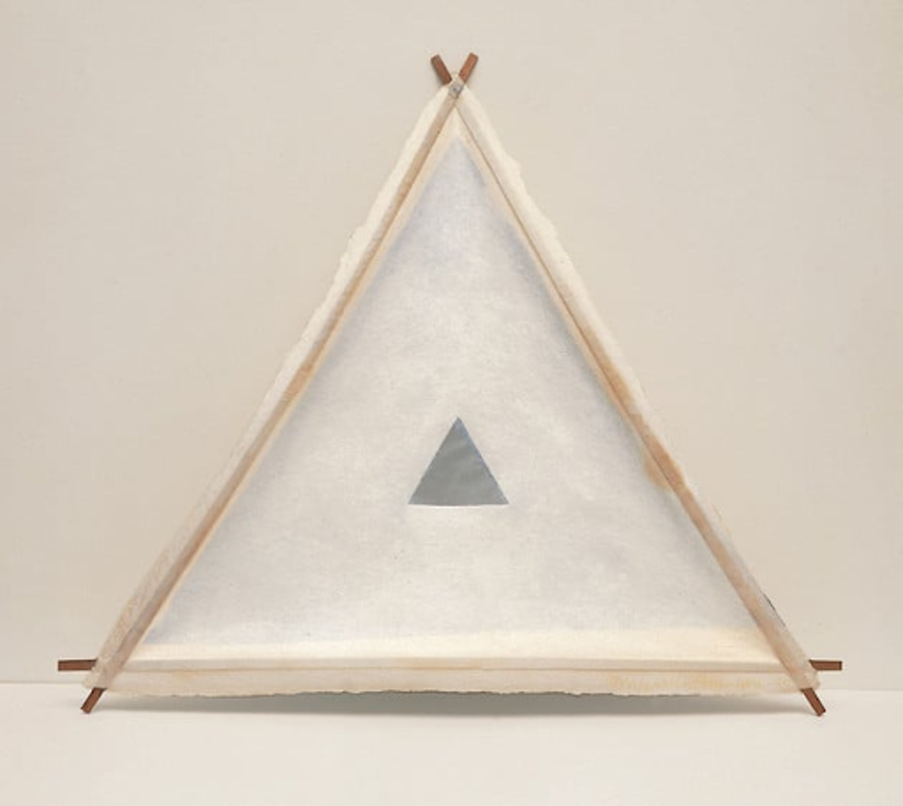 Robert Rauschnberg’s Little Joe (Bones). Three pieces of wood connecting to create a triangle with paper fabric covering it with a smaller, black triangle printed inside of it. 