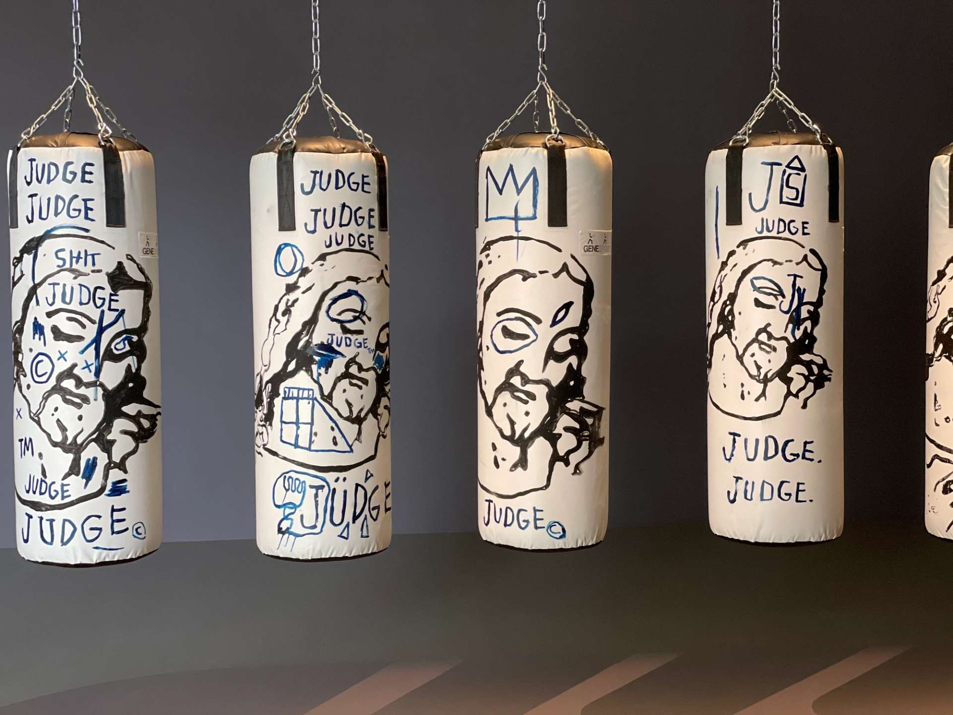 White punching bags with painted images of Christ