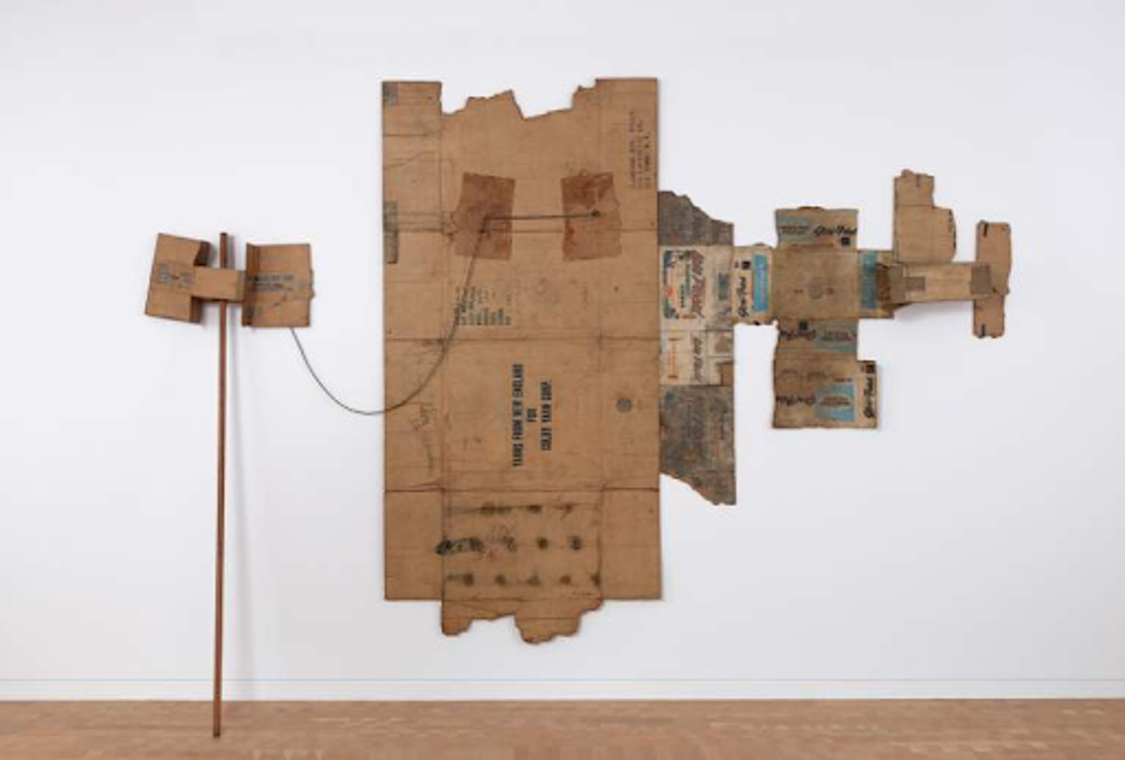 Robert Rauschnberg’s Lake Placid / Glori-Fried / Yarns from New England. An assemblage of cardboard boxes mounted on a white wall.