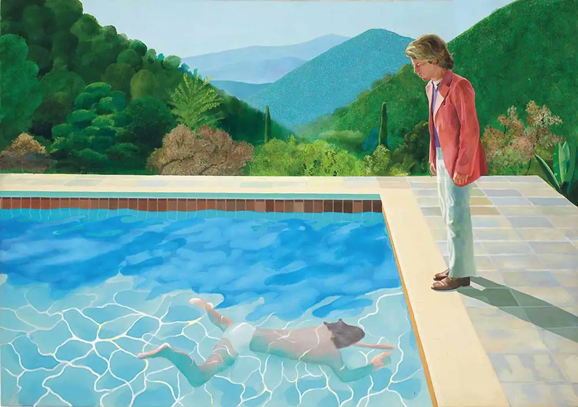 A man in a pink blazer stands over the edge of a pool, where another man swims under the water.
