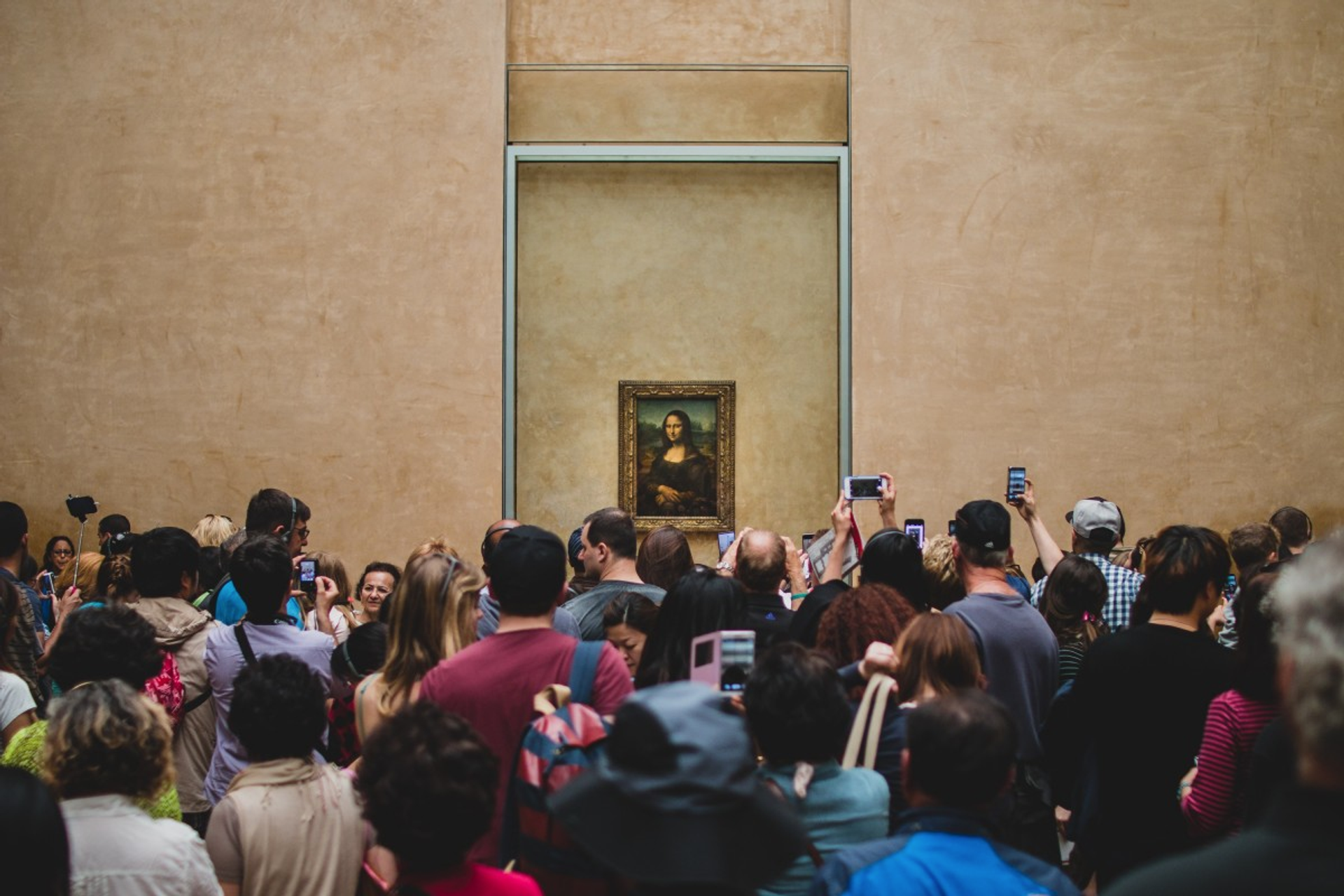 Interior view of The Louvre Museum. A crown of people taking photographs of the Mona Lisa