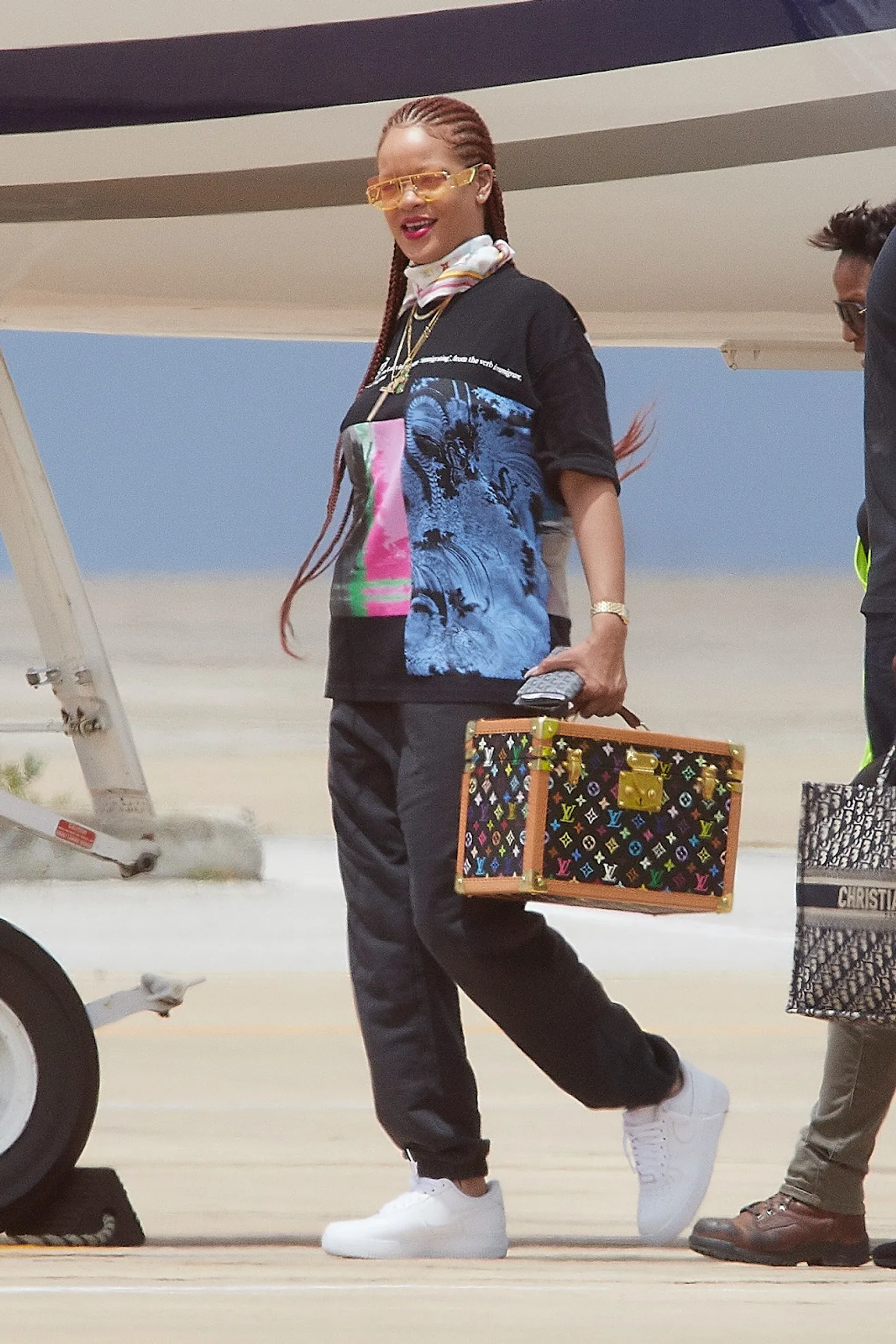 Image of singer, Rihanna, holding a vanity case with brightly coloured LV monograms across it
