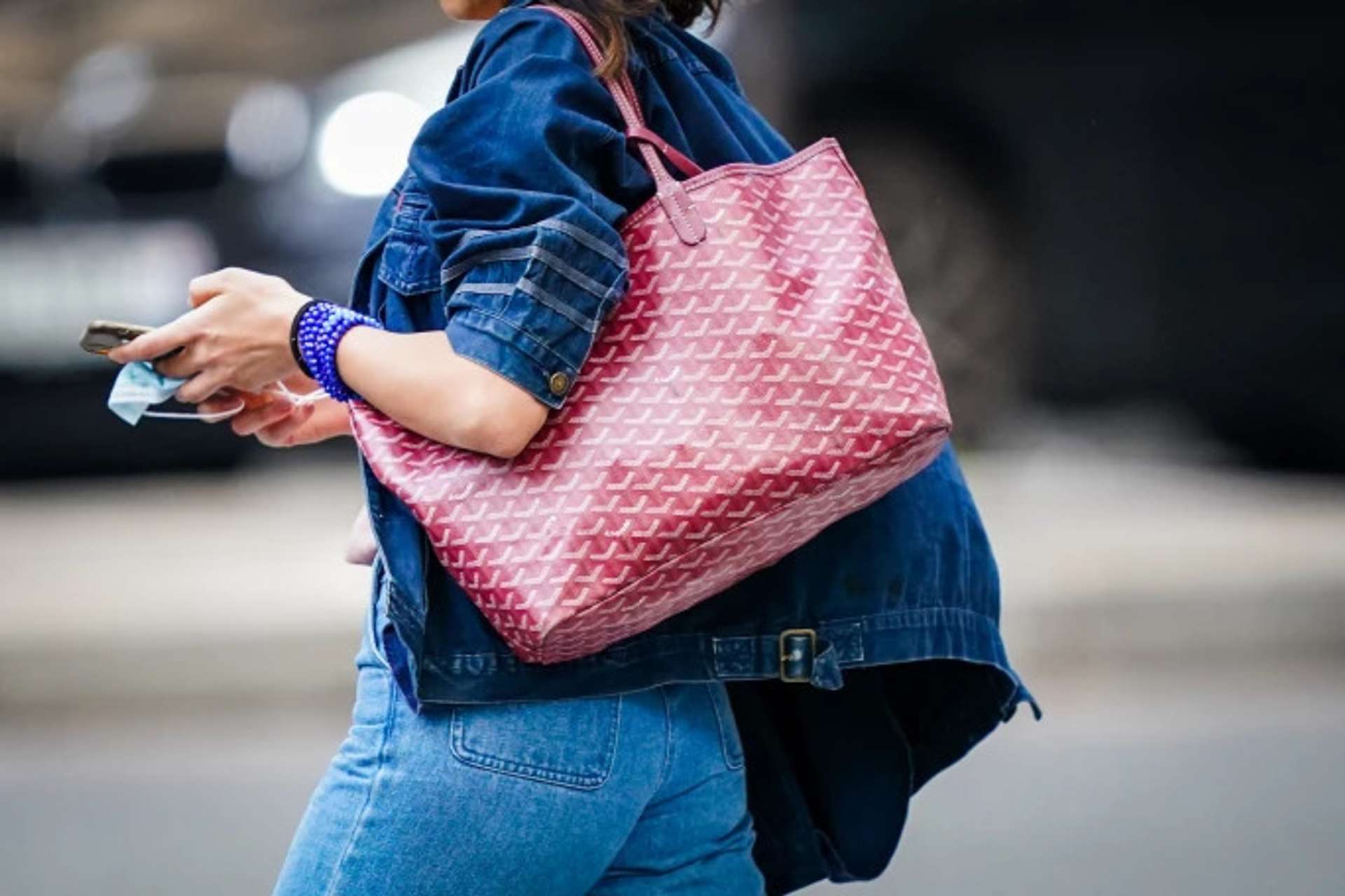 Woman walking carrying her Goyard purse on her shoulder