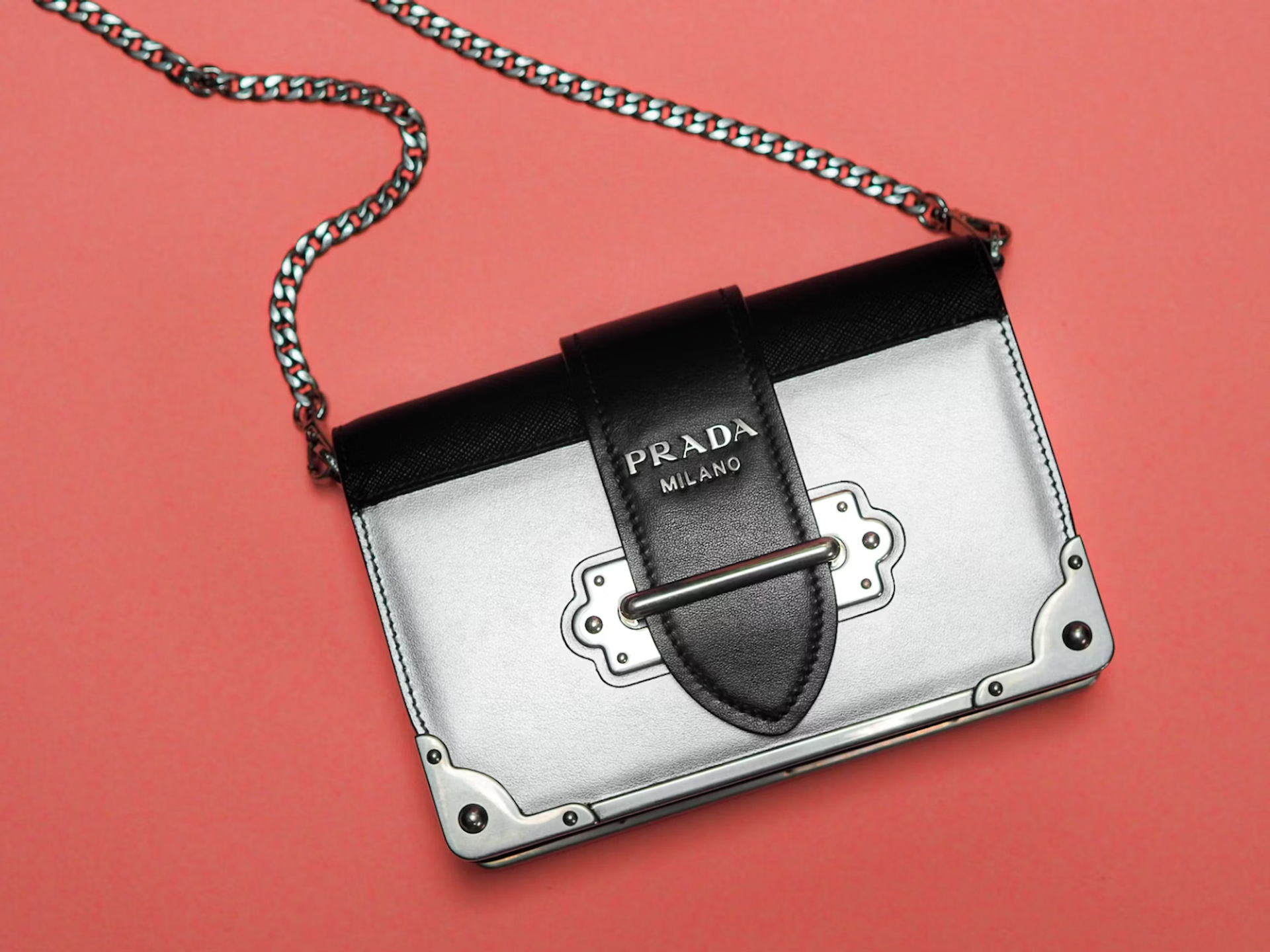 Prada handbag with silver hardware on a pink surface